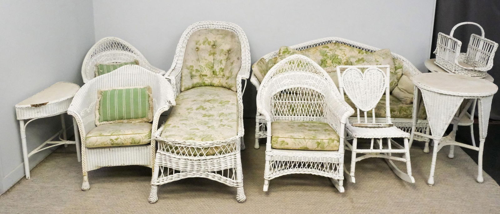 Large Group of White Wicker Furniture: Large group of vintage white wicker furniture, including three seat couch, chaise lounge, two arm chairs, two rocking chairs, three side tables, and a magazine rack, largest 37" H x 66 1/2" W x 27" L.