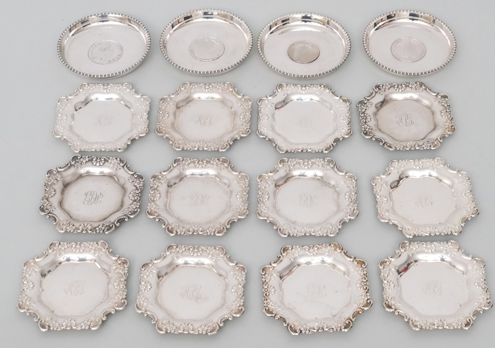 Two Sets of Sterling Silver Butter Pats: Comprising a set of British Colonial with coin insets and a set by Webster. Webster set 8.9 combined weight and the British Colonial 6.1 troy.