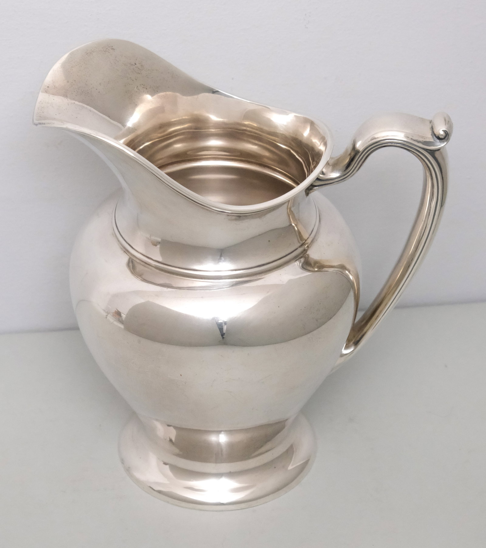 Reed & Barton Sterling Silver Water Pitcher: With fluted shoulder and handle. Hallmarked as shown. 21.9 troy.