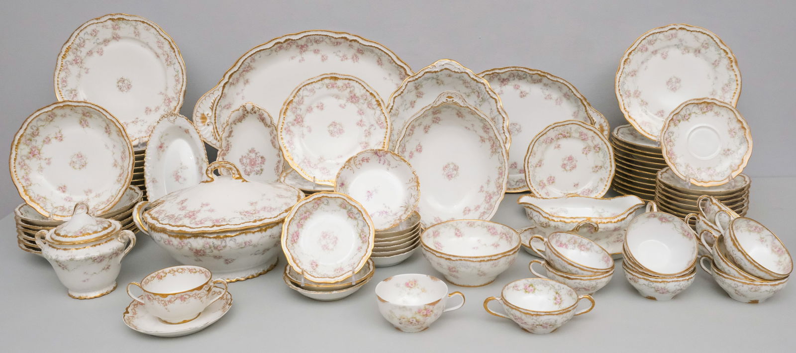 Large Set of Theodore Haviland Limoges Porcelain: Large set of Limoges with gilding and roses, comprising: (12) 9 3/4" dinner plates, (12) 8 3/4" luncheon plates, (11) 7 1/2" salad plates (one with rim chip), (7) 7 3/8" soup bows (2 with chips), (3)