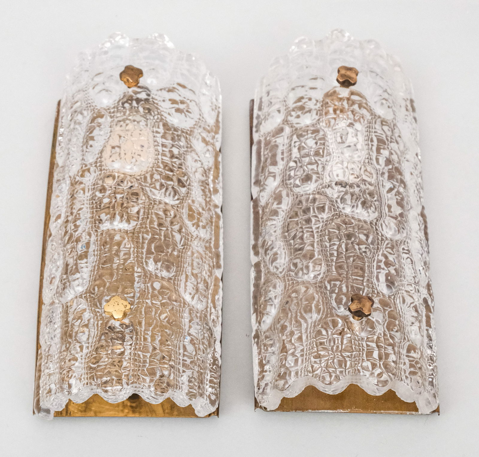 Pair Fagerland for Orrefors Lighting Fixtures: Pair of sconces in brass and textured ice glass, designed by Carl Fagerlund for Orrefors and Lyfa. Unlabeled. 5" x 11".