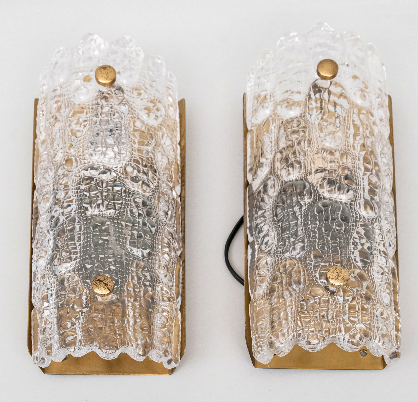 Pair Fagerland for Orrefors Lighting Fixtures: Pair of sconces in brass and textured ice glass, designed by Carl Fagerlund for Orrefors and Lyfa. Marked as shown. 5" x 11".