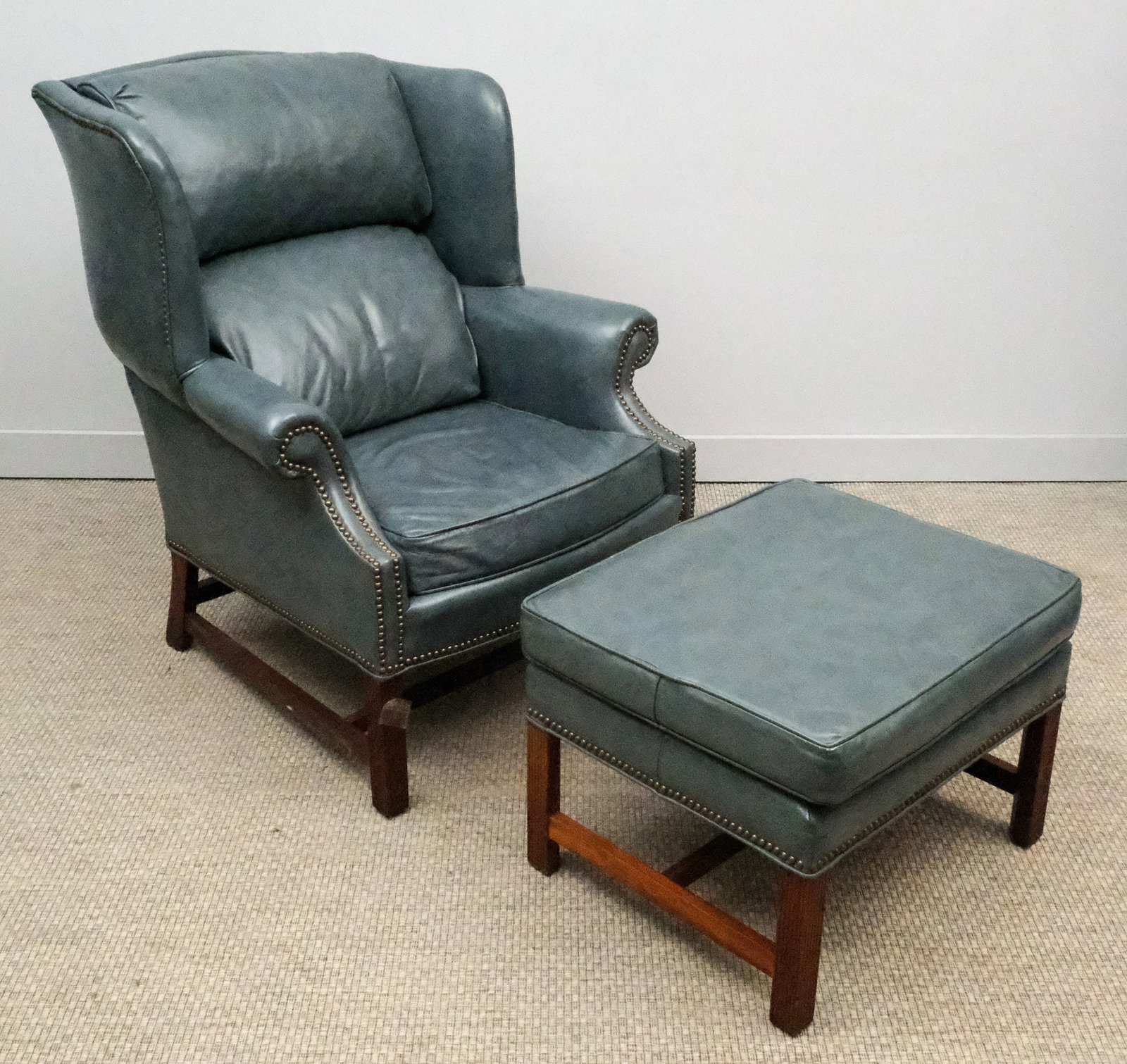 Lone Star Leather Armchair with Ottoman: Lone Star Leather light blue wingback armchair with ottoman with brass studs, chair 41" H x 30" W x 34" L, ottoman 18 1/2" H x 25 1/4" W x 21" L.