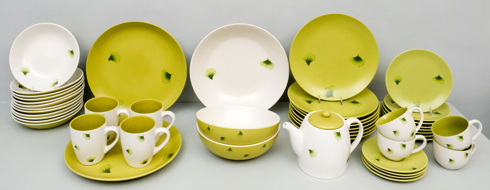 Yedi Houseware "Narita" China Dinner Service: With Gingko decor, comprising: (8) 10 1/2" dinner plates, (4) cups and saucers, (4) mugs, (12) bowls, (8) side plates, (2) chop plates, a teapot and (3) serving bowls.