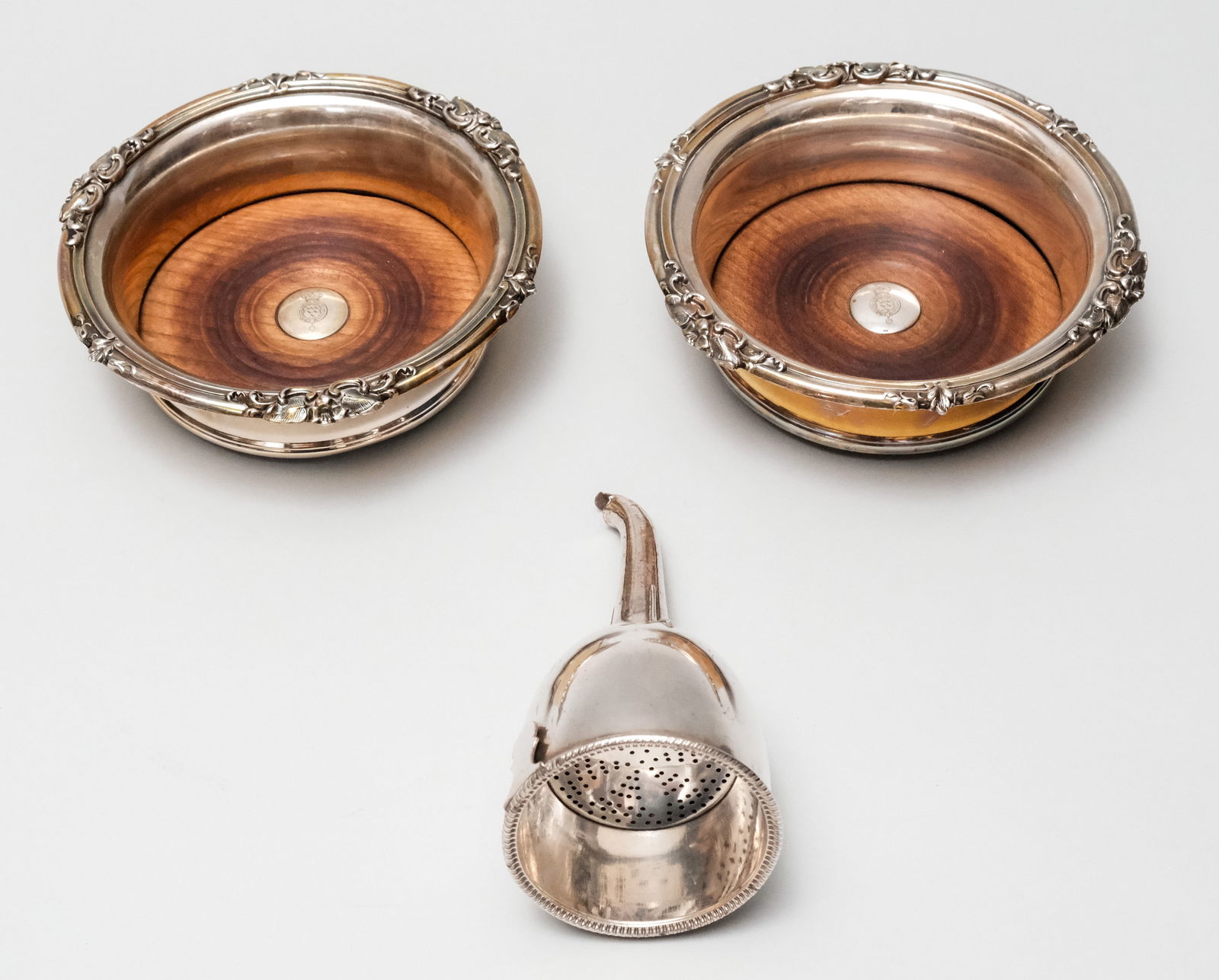 Pair of Antique Silverplate Wine Coasters: Of military interest, engraved with the armorial of the Royal Sussex Regiment of Artillery. Together with a wine funnel. Coasters 6 3/4" diameter.