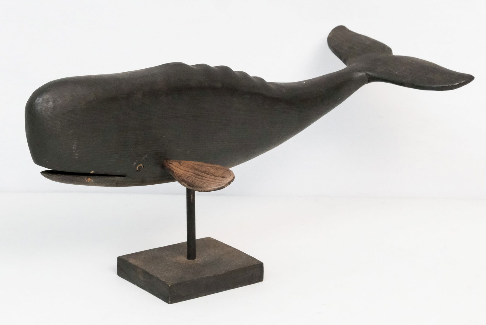 Carl Jensen Wood Carved Sperm Whale Sculpture: (American, 1939-2024) Carved and painted decoy style whale, fitted on stand. Signed at bottom.