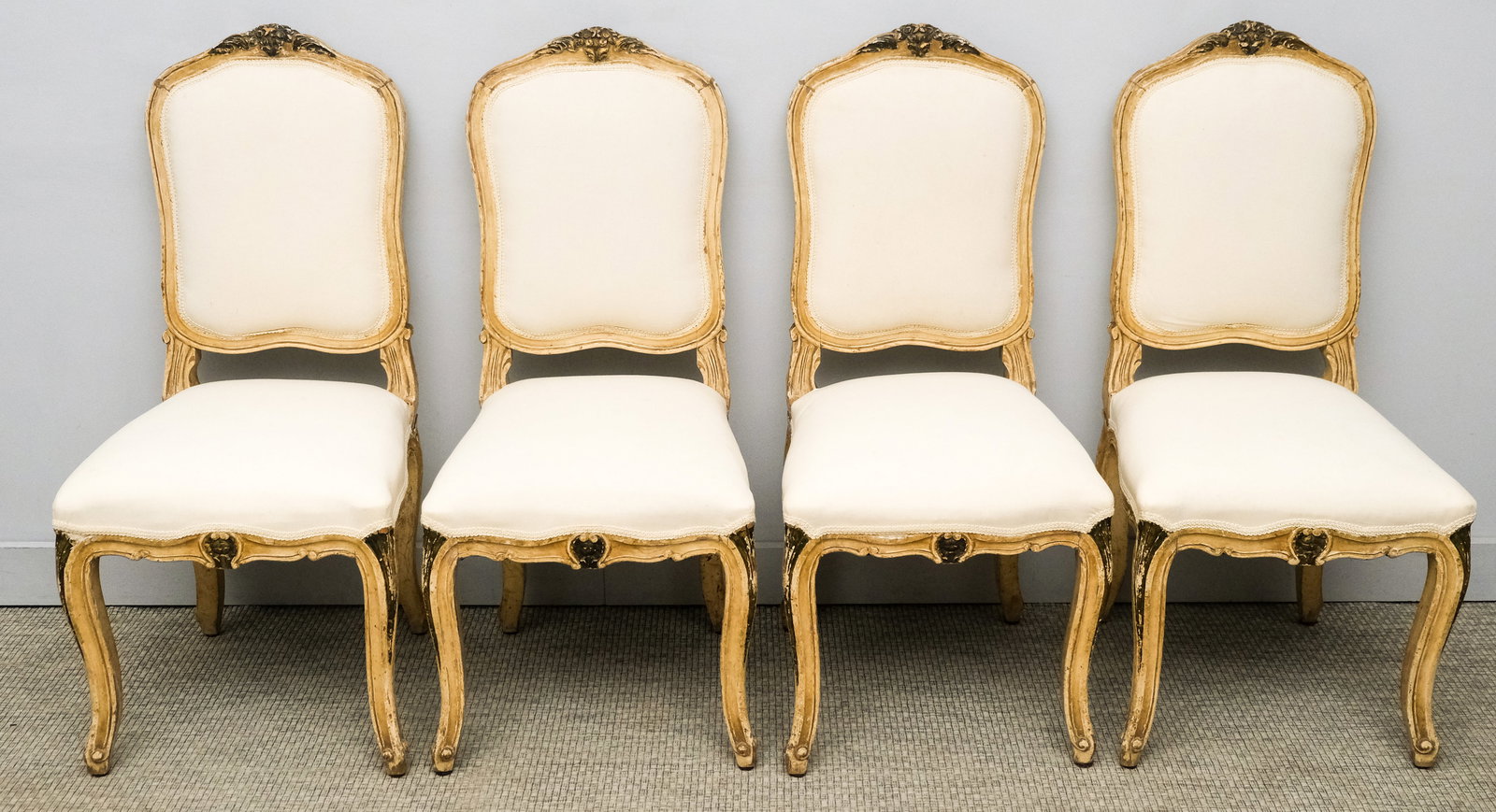 Four Carved and Painted Parcel Gilt Chairs: French, 20th century, possibly older, having muslin seats, 39" H x 17 1/2" W x 17 3/4" D.
