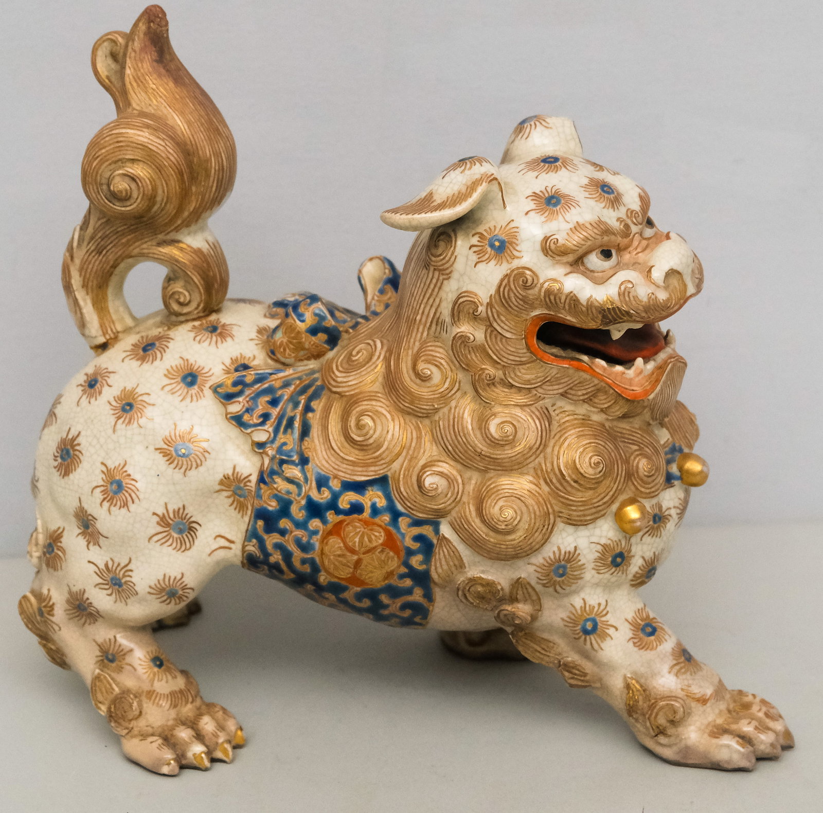 Antique Japanese Satsuma Porcelain Foo Dog: Well painted passant form with gilt highlights.