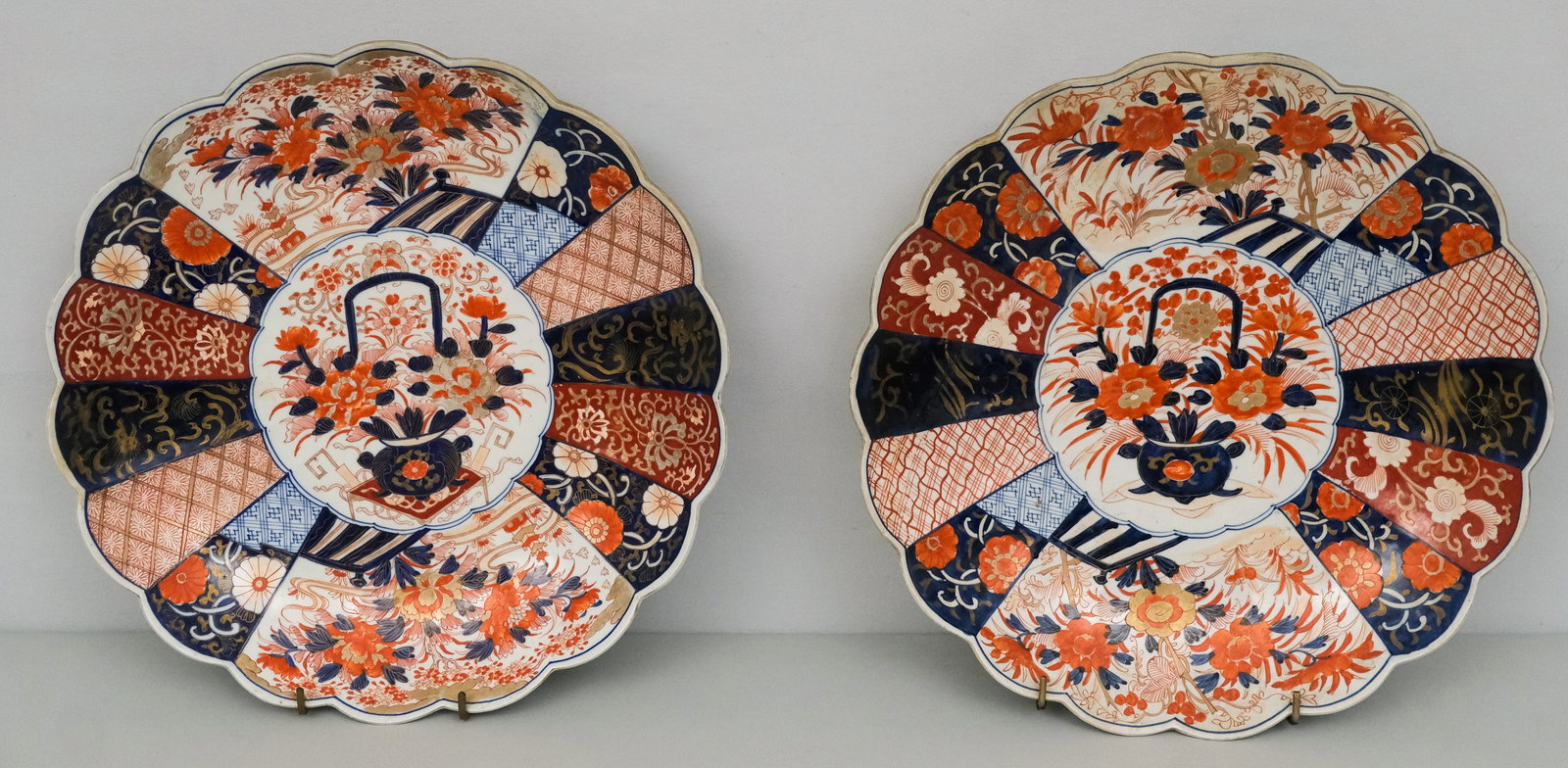 Pair of Japanese imari Porcelain Chargers: In traditional palette with asymmetrical cartouche and flower basket central medallion 18 1/4" diameter x 2 7/8"