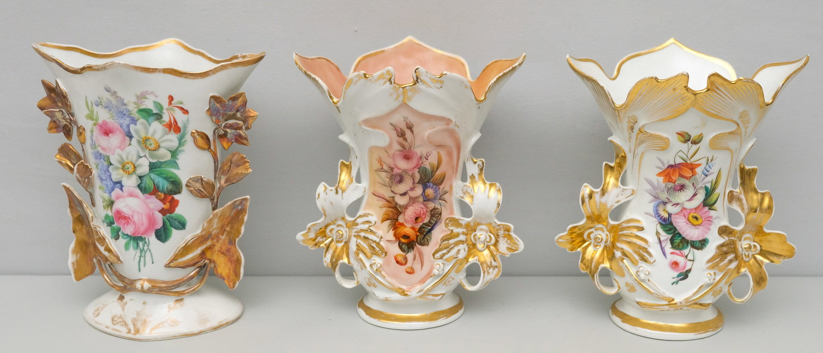 Pair of Old Paris Porcelain Mantle Vases: Pulled leaf forms with floral handles, hand painted with heavy gold gilt work. Each 11 1/4" x 9"