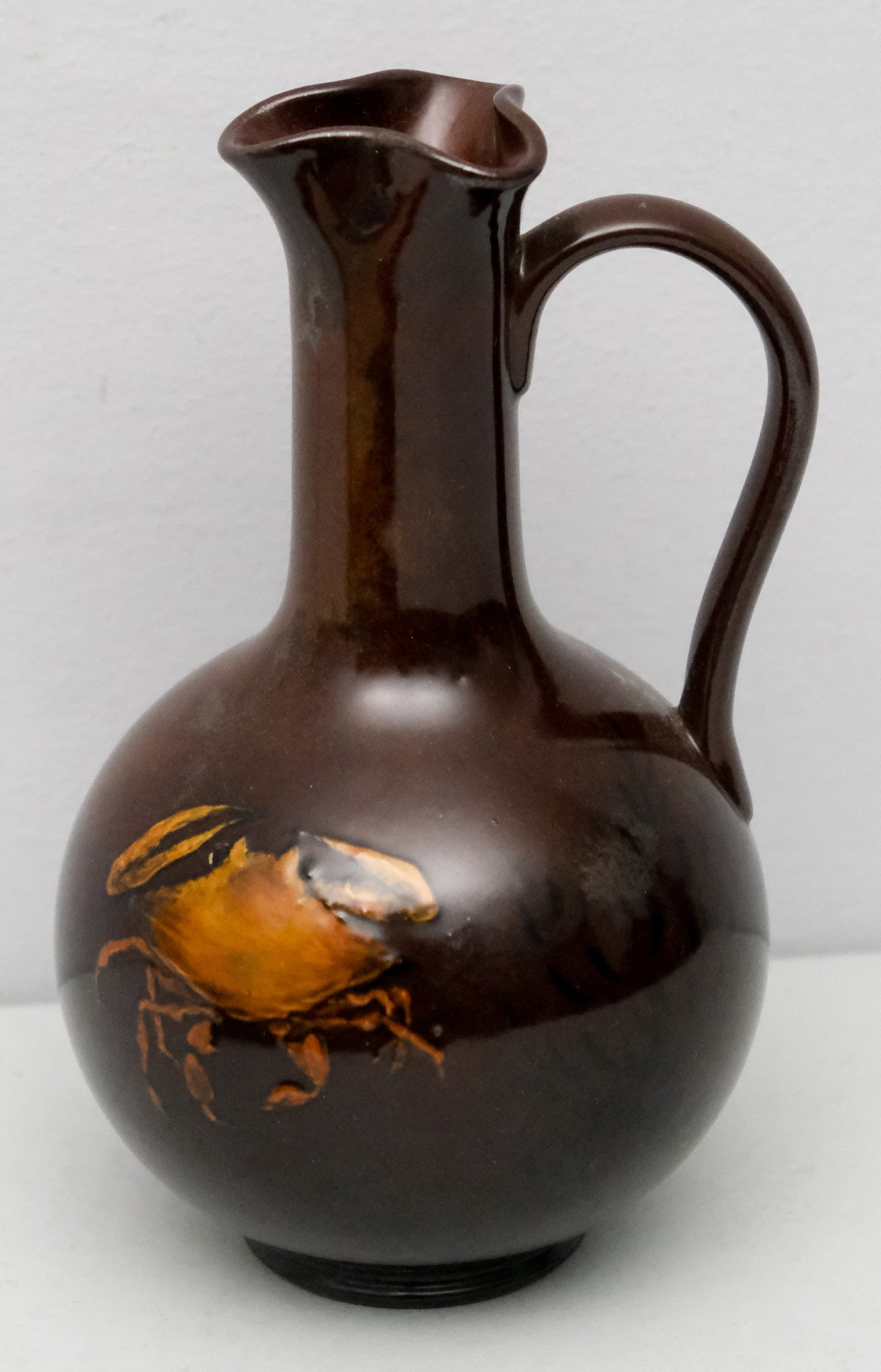 Early Rookwood Aesthetic Pottery Jug: C.1883-1885 Artist signature of Mary Aldis Taylor. Decorated with seaweed and splashes of silver lustre, as well as crabs in high relief. 8 1/4" height.