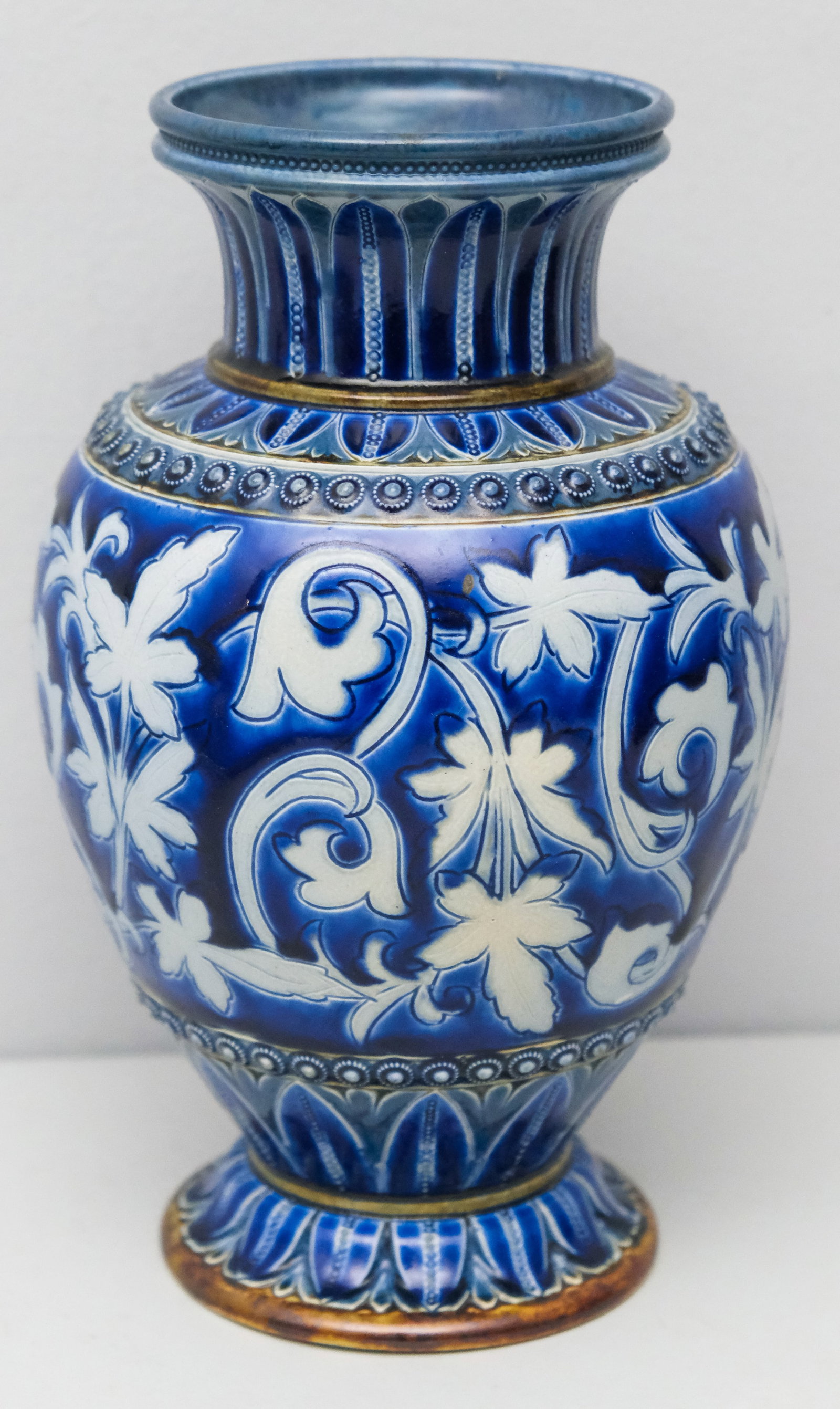 Edith Lupton for Doulton Lambeth Pottery Vase: Incised cream, white and gray foliage and applied studs on cobalt blue background. 10". Impressed marks and incised initials for Lupton. 10 1/4"