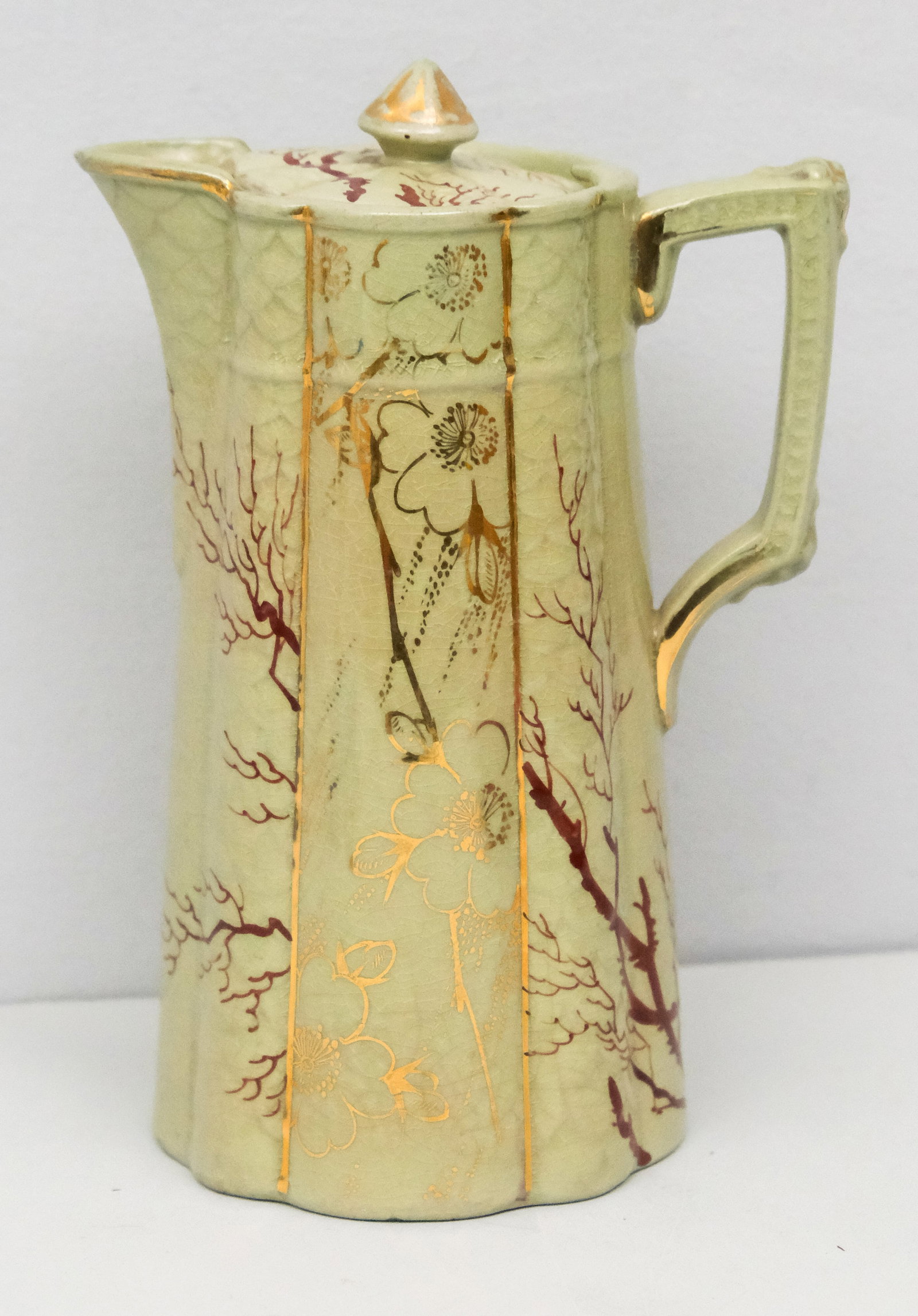 New England Pottery Rieti Coffee Pot: Ribbed pale green body with scraggly trees and gilt florals. Marked as shown. 7 1/2".