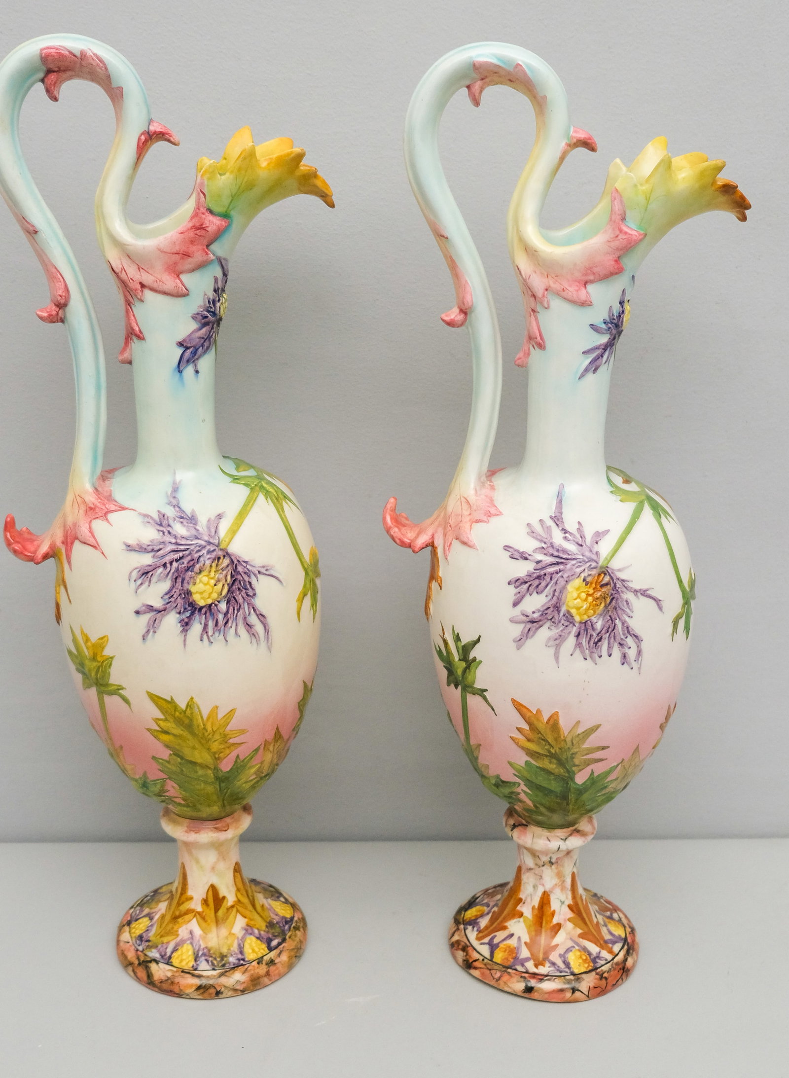 Pair of Massive Delphin Massier Art Pottery Ewers: Massive ewer form pitchers with applied floral decoration and foliate elements. Hand painted bodies. Striking. Marked as shown. 21".
