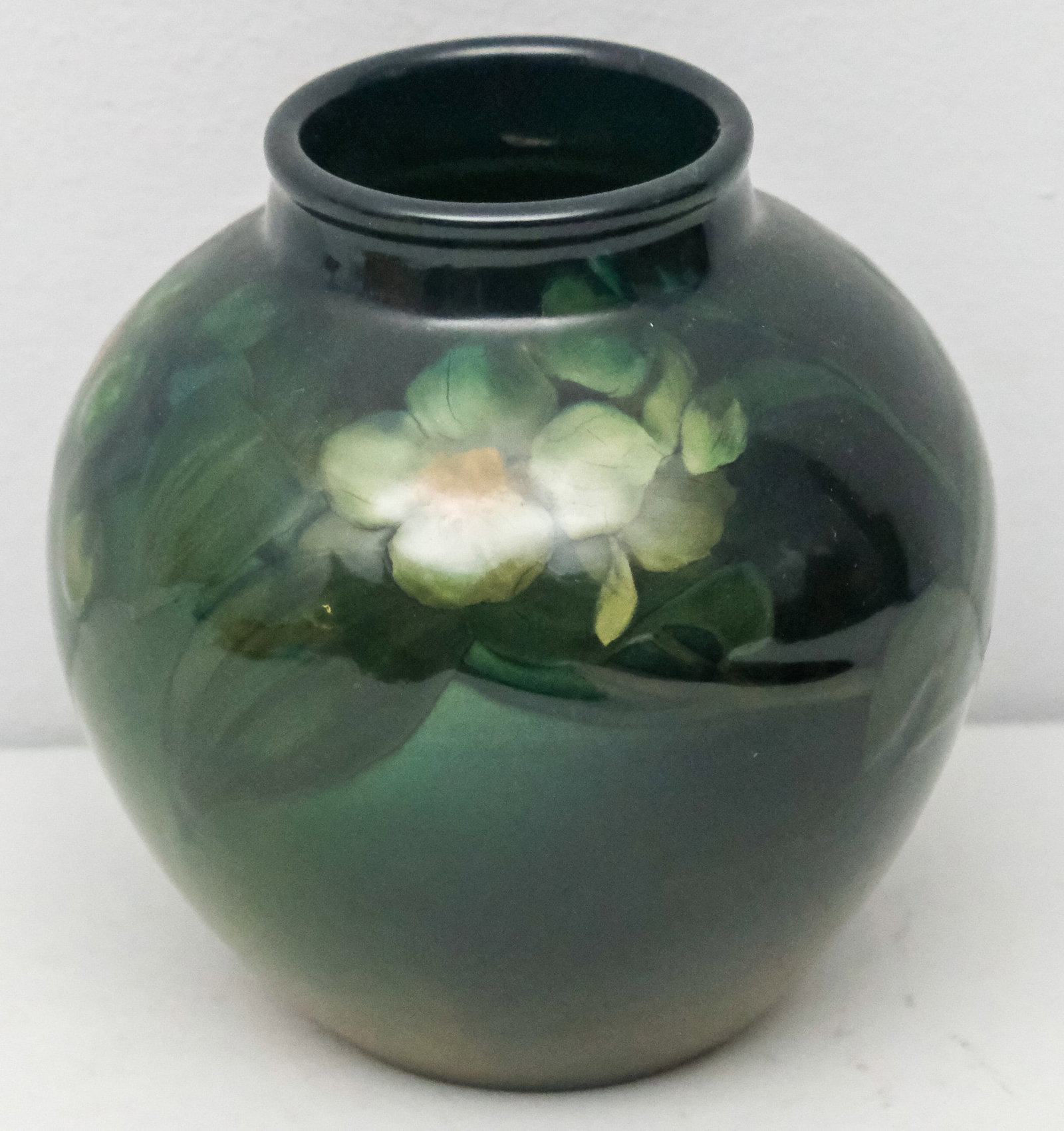 Rookwood Art Pottery Vase by Sallie Toohey: C. 1901, Model 912 by Sarah Alice Toohey. Tan shaded to navy blue decorated in shadowy white flowers. Measures 5 1/4".