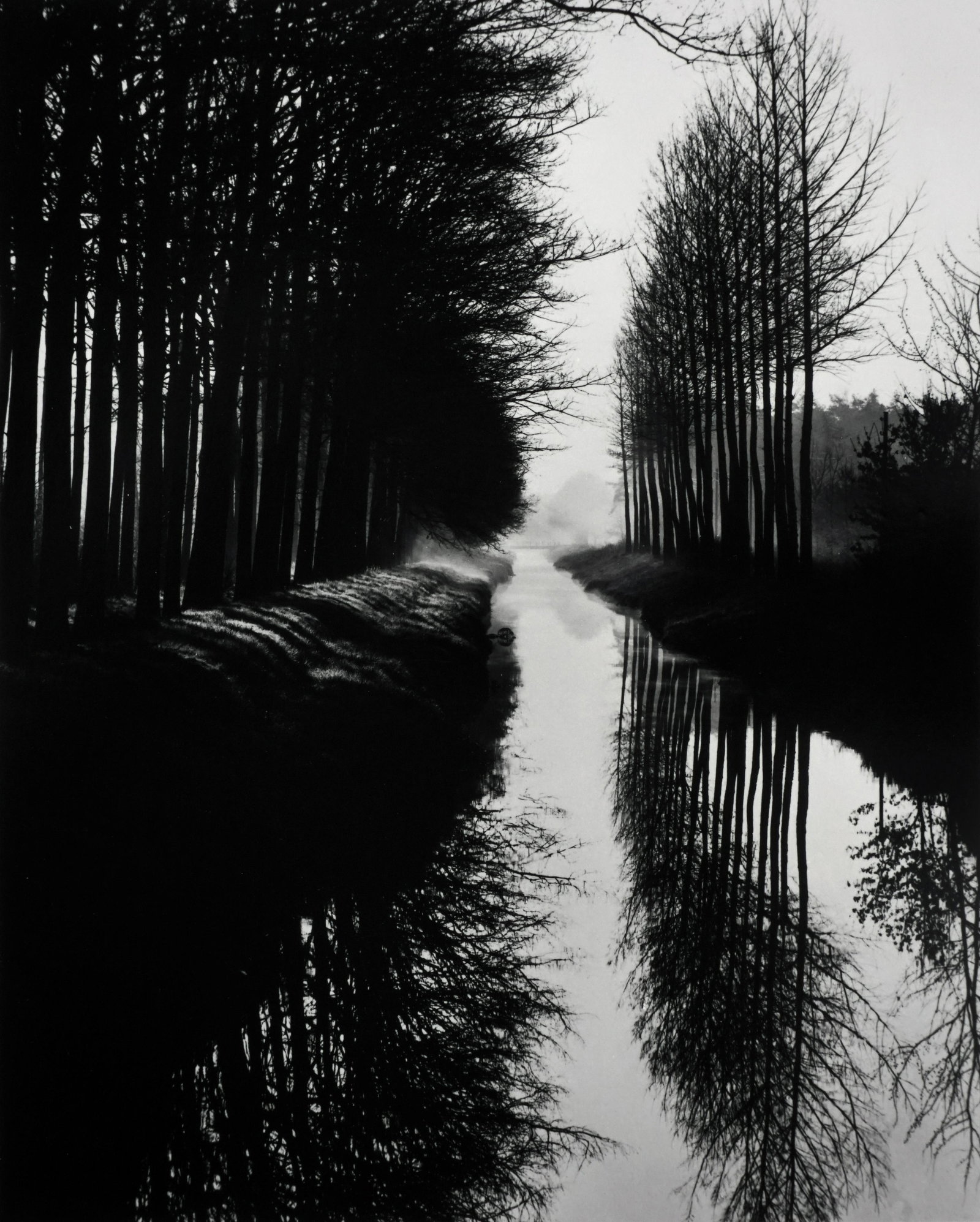 BRETT WESTON - Holland Canal, 1971 - Unsigned Silver: ARTIST: BRETT WESTON TITLE: "Holland Canal, 1971" MEDIUM: Silver gelatin print, mounted. Printed c. 1970s SIZE: Image - 7 ½" x 9 ½", Mount - 14" x 18", Mat - 16" x 20" DESCRIPTION: