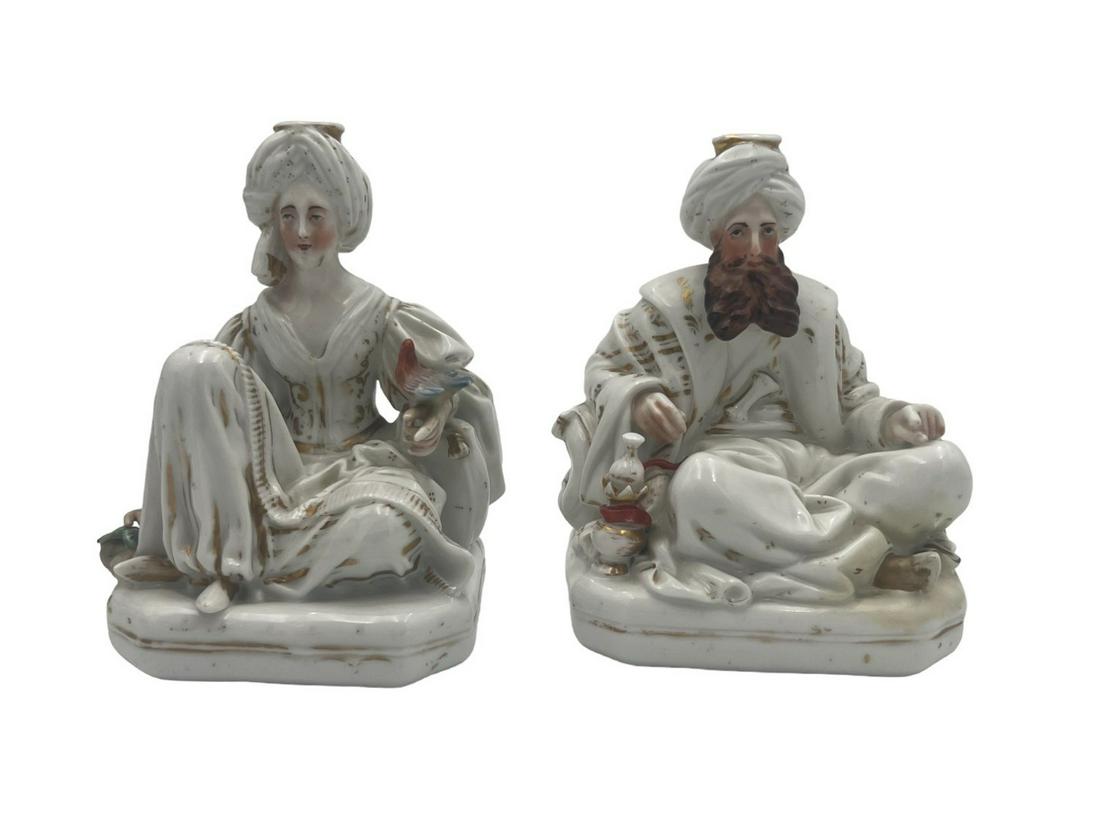 Jacob Petit Paris: Jacob Petit ParisTwo Jacob Petit porcelain candlesticks or flasks in polychrome and gilded enameled porcelain in the form of a Sultan and Sultana each seated on a large cushion, with aperture in turba