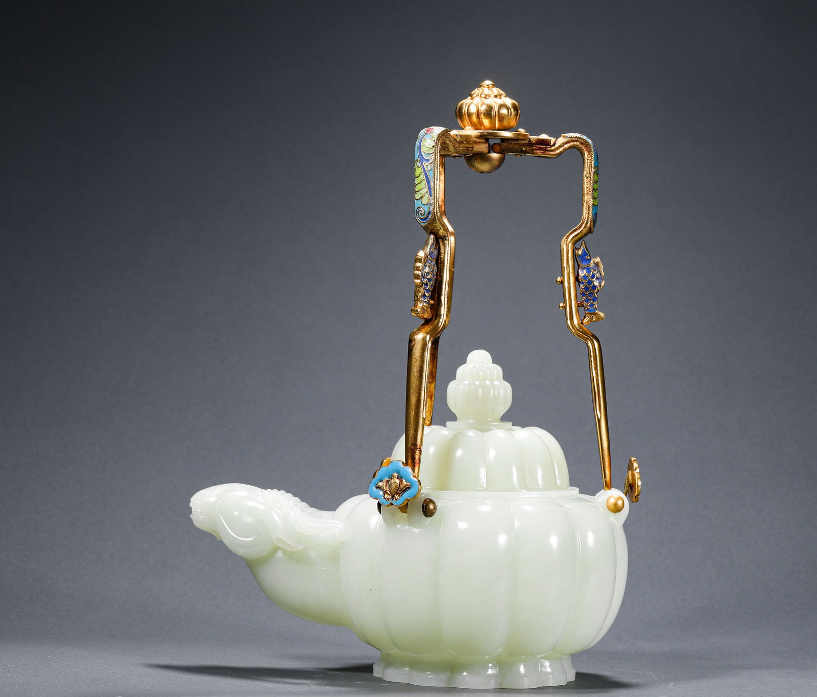 QING DYNASTY, QIANLONG HETIAN JADE HANDLE SHEEP HEAD POT: Name QING DYNASTY, QIANLONG HETIAN JADE HANDLE SHEEP HEAD POT Dimensions H:24cm W:24cm Weight:820g This is a Qing Dynasty court-style Hetian white jade melon-shaped handle teapot. The body of the teap