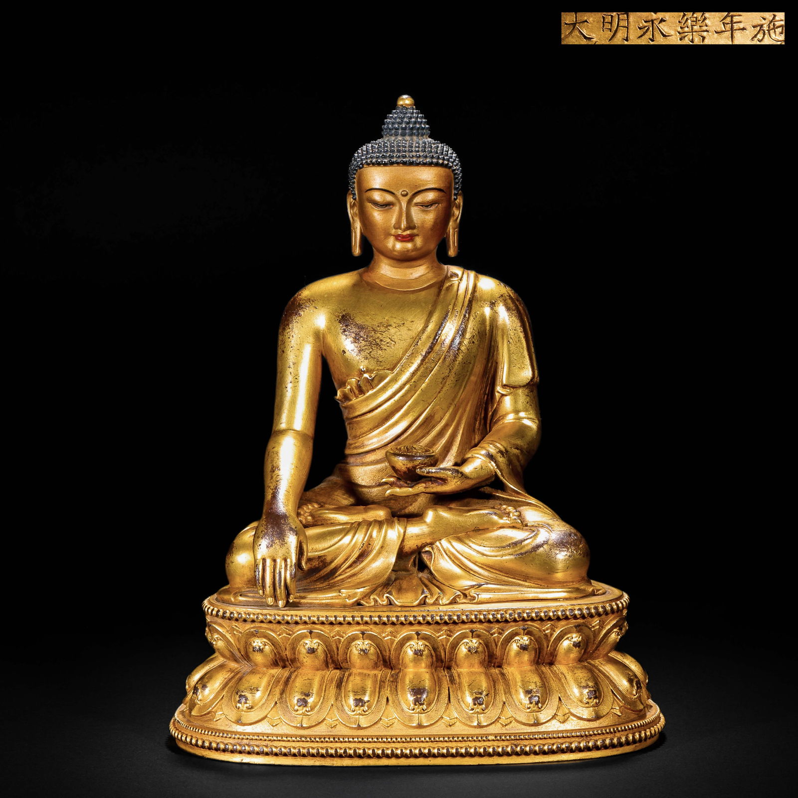 A GILDED BRONZE STATUE OF SAKYAMUNI BUDDHA FROM YONGLE, MING DYNASTY: Name A GILDED BRONZE STATUE OF SAKYAMUNI BUDDHA FROM YONGLE, MING DYNASTY Dimensions H:15cm W:11cm Weight850g This is a gilded bronze sitting statue of the Medicine Buddha with the inscription "Given
