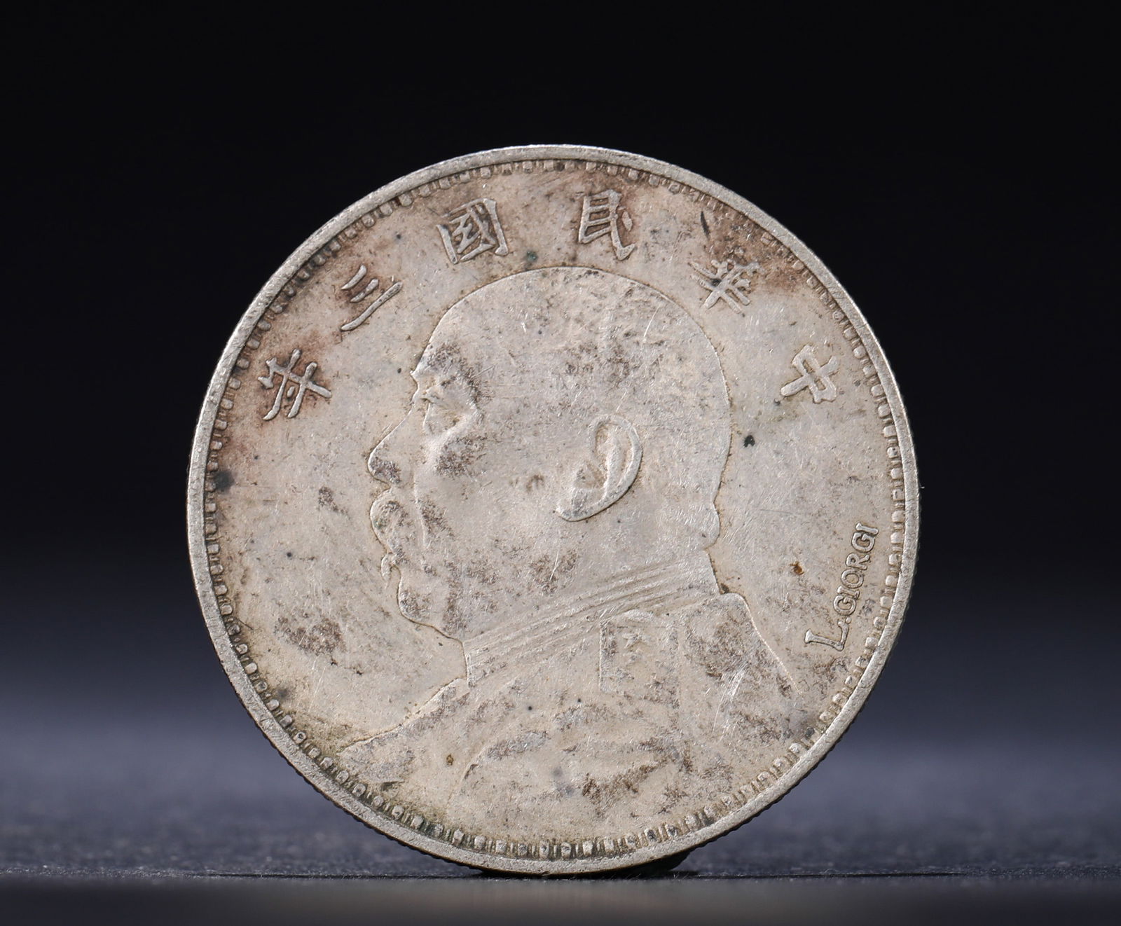 A SIGNED SILVER COIN FROM THE THIRD YEAR OF THE REPUBLIC OF CHINA: Name A SIGNED SILVER COIN FROM THE THIRD YEAR OF THE REPUBLIC OF CHINA Dimensions D:3.9cm Weight:27g Condition Additional photographs and condition reports are available upon reque
