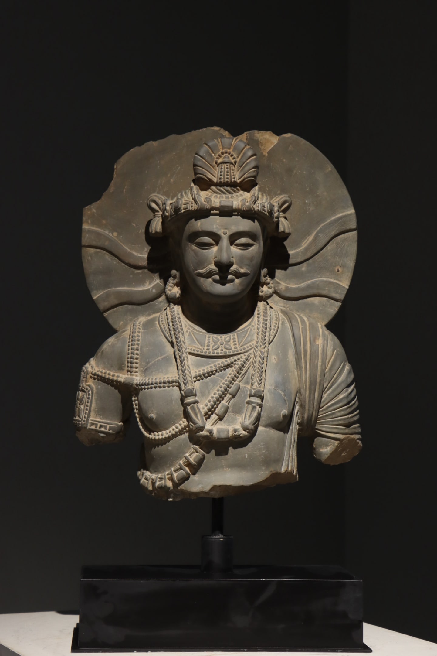 3RD CENTURY GANDHARA: Name 3RD CENTURY GANDHARA Dimensions H: 55 CMTHIS IS A GANDHARA-STYLE BUST OF A BODHISATTVA CARVED FROM GRAY SHALE, DATIN G FROM THE 2ND TO 3RD CENTURY CE, A CLASSIC EXAMPLE OF GANDHARA ART THAT FUSES