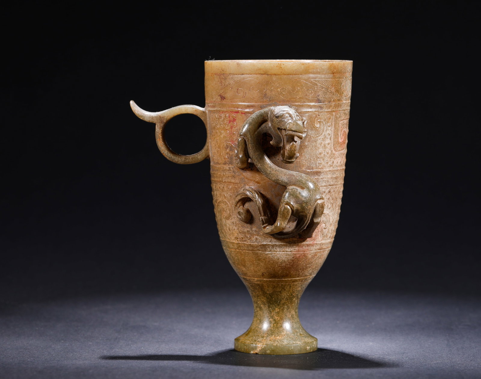 A HIGH-FOOTED JADE CUP WITH COILED DRAGON PATTERN FROM THE HAN DYNASTY (1 of 8)