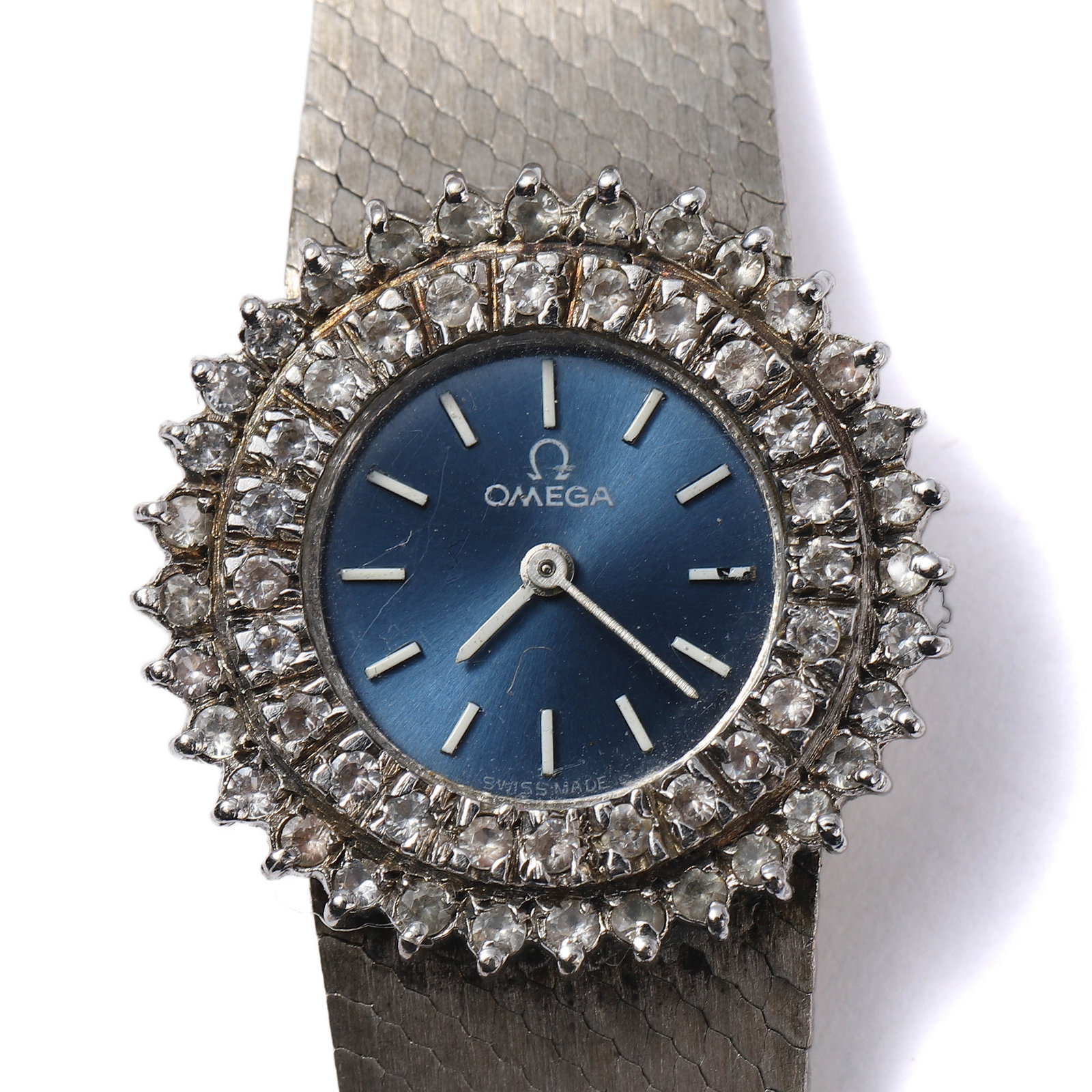 OMEGA VINTAGE LADIES' DIAMOND-SET WRISTWATCH.: length: 16 in (40.6 cm); dial length: 11/16 in (1.7 cm) Description: A vintage Omega ladies' wristwatch featuring a silver-tone case and bracelet with an elegant textured finish. The watch is adorned