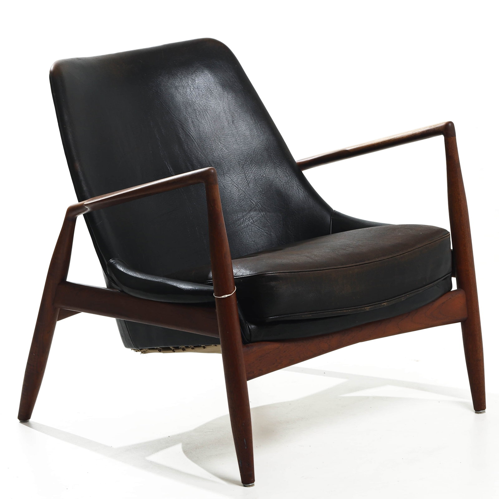 IB KOFOD-LARSEN "SEAL" LOUNGE CHAIR FOR OPE, TEAK AND LEATHER: Dimensions Height 29 1/2 in. (75 cm), Seat height 15 3/8 in. (39 cm), Width 31 1/2 in. (80 cm) Description Designed in 1956 by Danish designer Ib Kofod-Larsen and produced by OPE in Sweden, the "Seal"