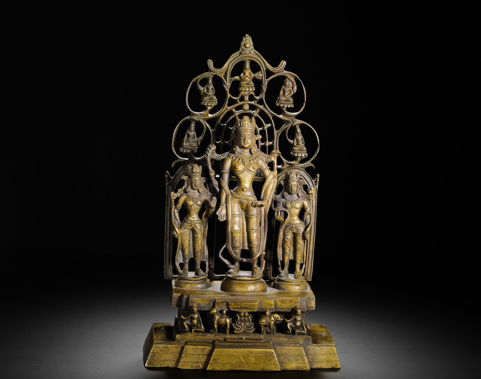 10TH-CENTURY COPPER ALLOY GROUP STATUE OF GUANYIN BODHISATTVA: H:27cm(10.63in) W:16cm(6.30in) Weight:1730g(3.81lb)The central figure of Avalokiteshvara stands on a lotus pedestal, flanked by attendant deities. The openwork backplate features smaller Buddhas, and 