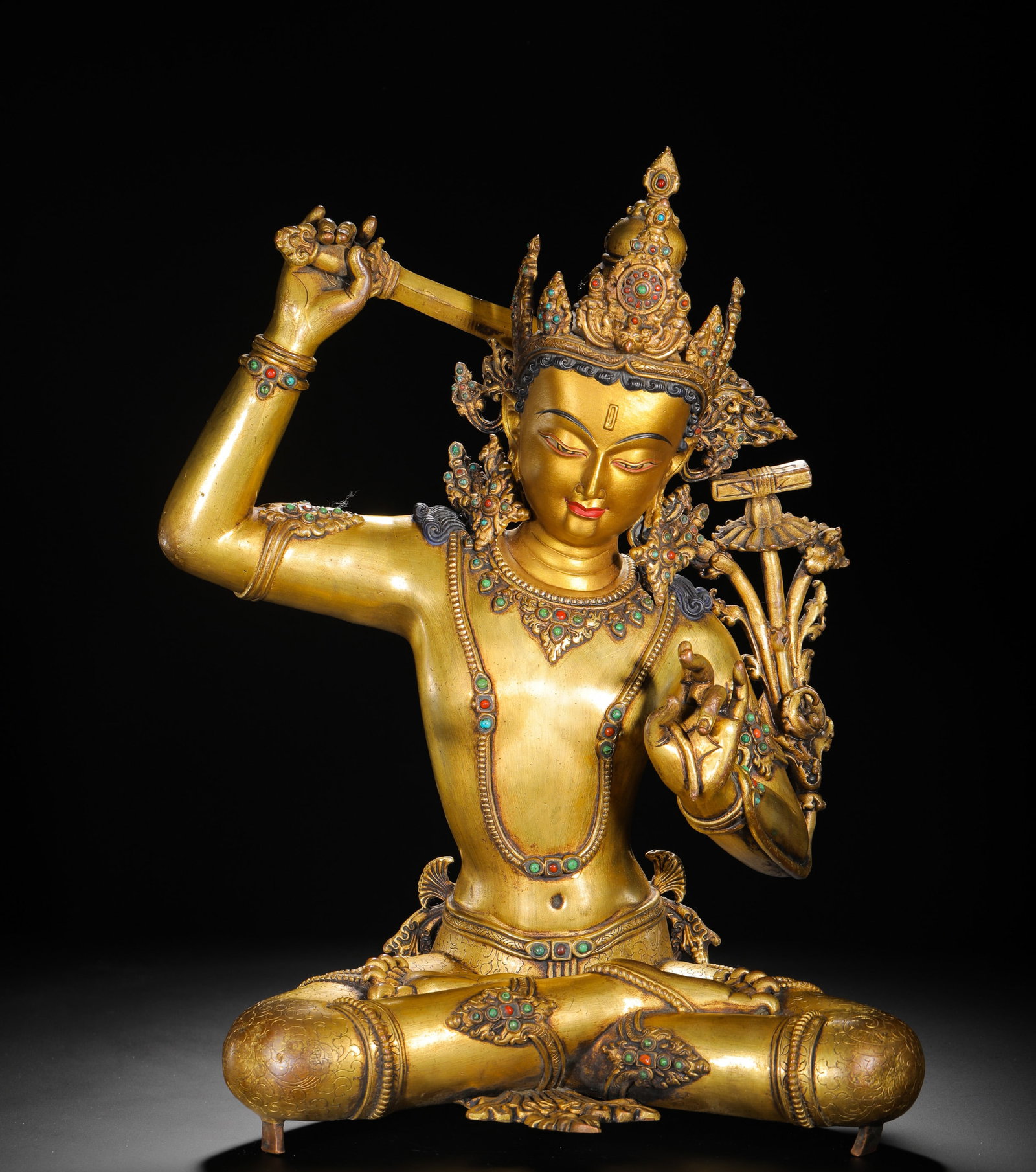 A GILDED BRONZE STATUE OF MANJUSRI BODHISATTVA FROM THE QING DYNASTY: H:43cmW:33cmWeight:7650g This is a gilt bronze statue of Manjushri with gemstone inlay from the Qing Dynasty, representing the embodiment of wisdom in Tibetan Buddhist art, crafted with exquisite tech