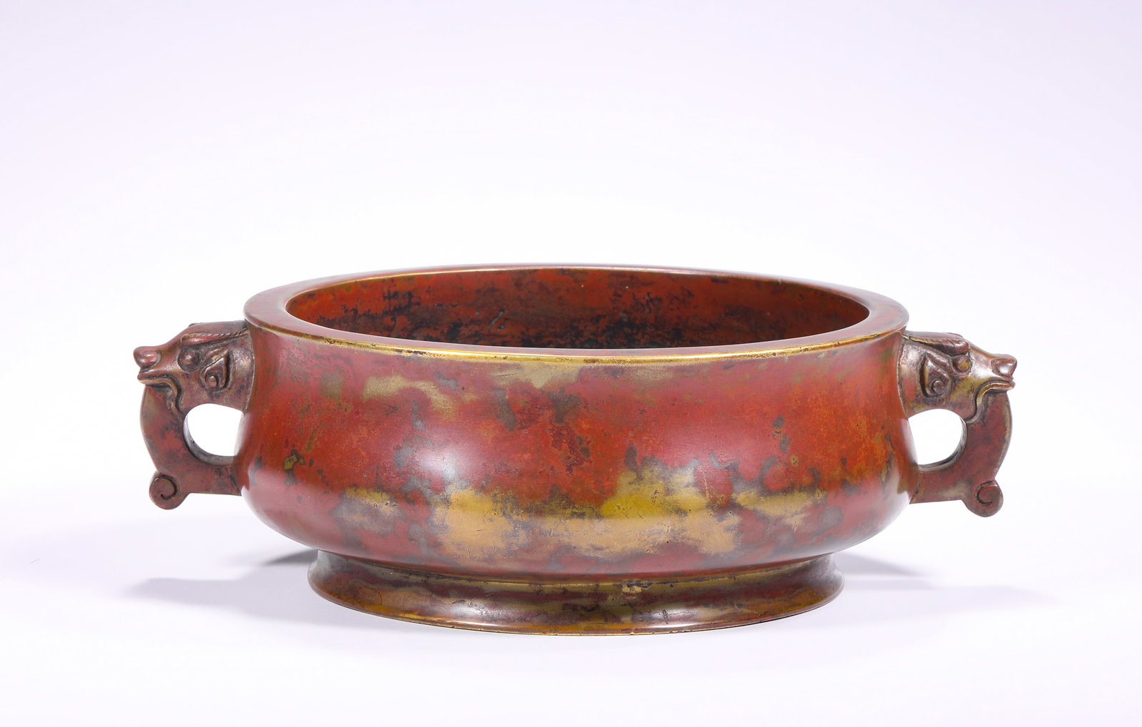 BRONZE BODY JUJUBE RED SKIN BEAST EAR GUIZI-STYLE FURNACE OF THE QING DYNASTY: H:5.5cm(2.17in) D:18.5cm(7.28in) Weight:1410g(3.11lb)This censer is a masterpiece of study bronze in the Qing Dynasty, imitating the style of Xuande Furnace. Made of fine copper as the base, it forms 