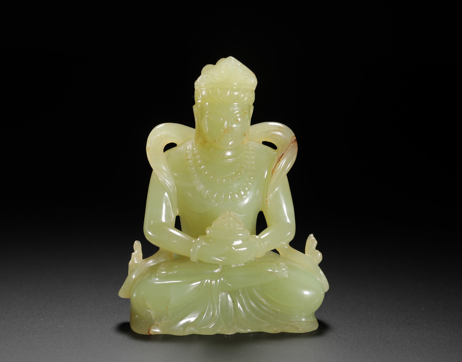 A YELLOW JADE SITTING BUDDHA STATUE FROM THE QING DYNASTY: H:7.8cm(3.07in)W:6cm(2.36in)Weight:130g(0.29lb)This is a Qing Dynasty yellow jade seated Buddha statue, depicted in the lotus position holding a ritual vessel, with a serene and compassionate expressi