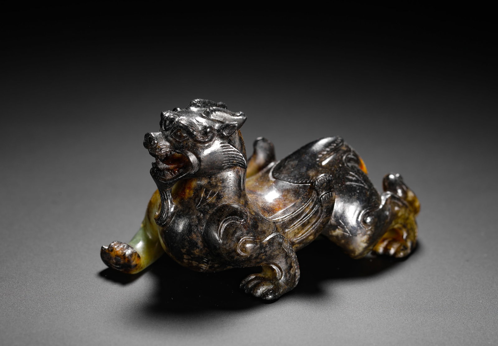 HAN DYNASTY HETIAN JADE TIANLU AUSPICIOUS BEAST: H:4.5cm(1.77in) W:8cm(3.15in) Weight:130g(0.29lb)This is a Han Dynasty jade Tianlu mythical beast ornament, entirely covered in mercury patina, carved in the round in a fierce, lunging pose with power