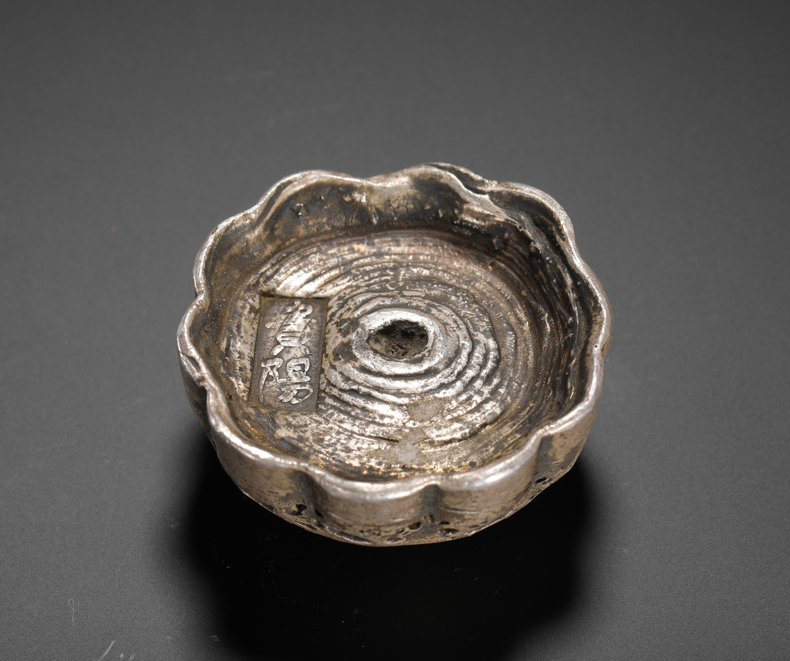 A FIVE-TAEL CAMELLIA-SHAPED SILVER INGOT FROM GUIYANG IN THE QING DYNASTY: H:3cm(1.18in) W:5.5cm(2.17in) Weight:340g(0.75lb)As a local currency in Guizhou, it was used for tax payments and trade, and is now valued for its unique form and rarity