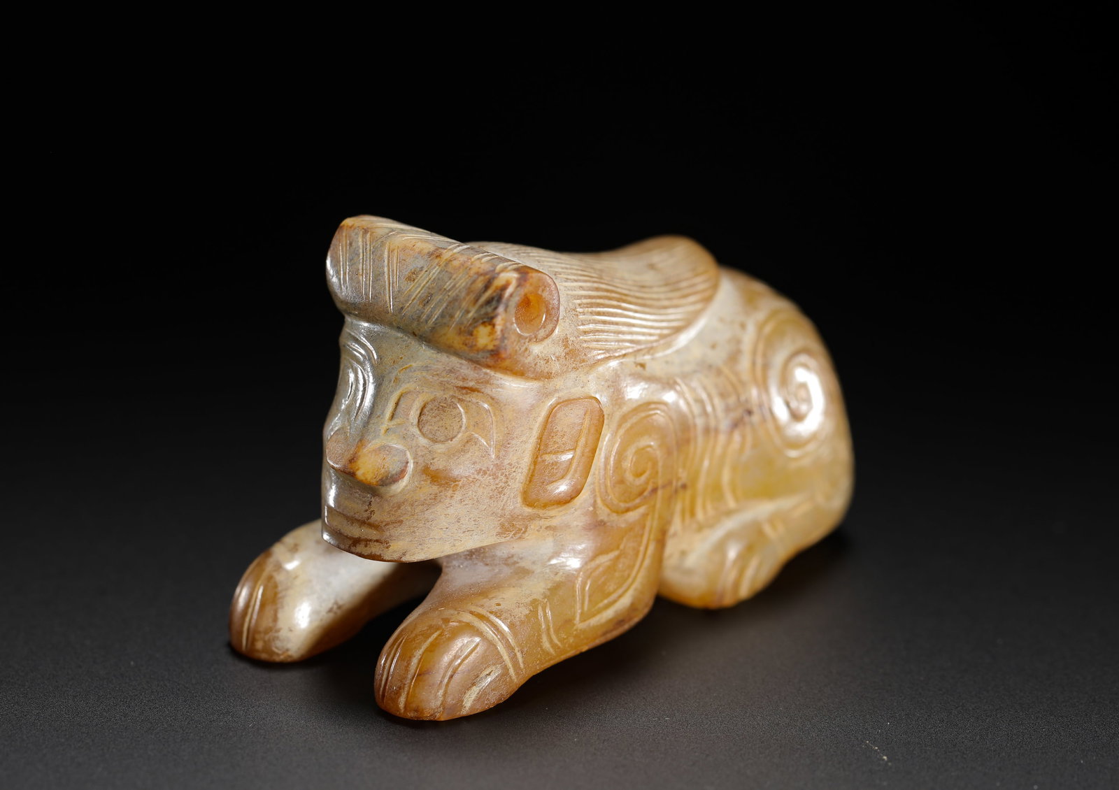 JADE HUMAN FACE AND BEAST BODY AUSPICIOUS BEAST OF THE SHANG DYNASTY: H:3.8cm(1.50in)W:6.3cm(2.48in)Weight:100g(0.22lb)This is a Shang Dynasty jade hybrid creature with a human face and animal body, carved in the round with archaic, bold lines and natural patina. Used a