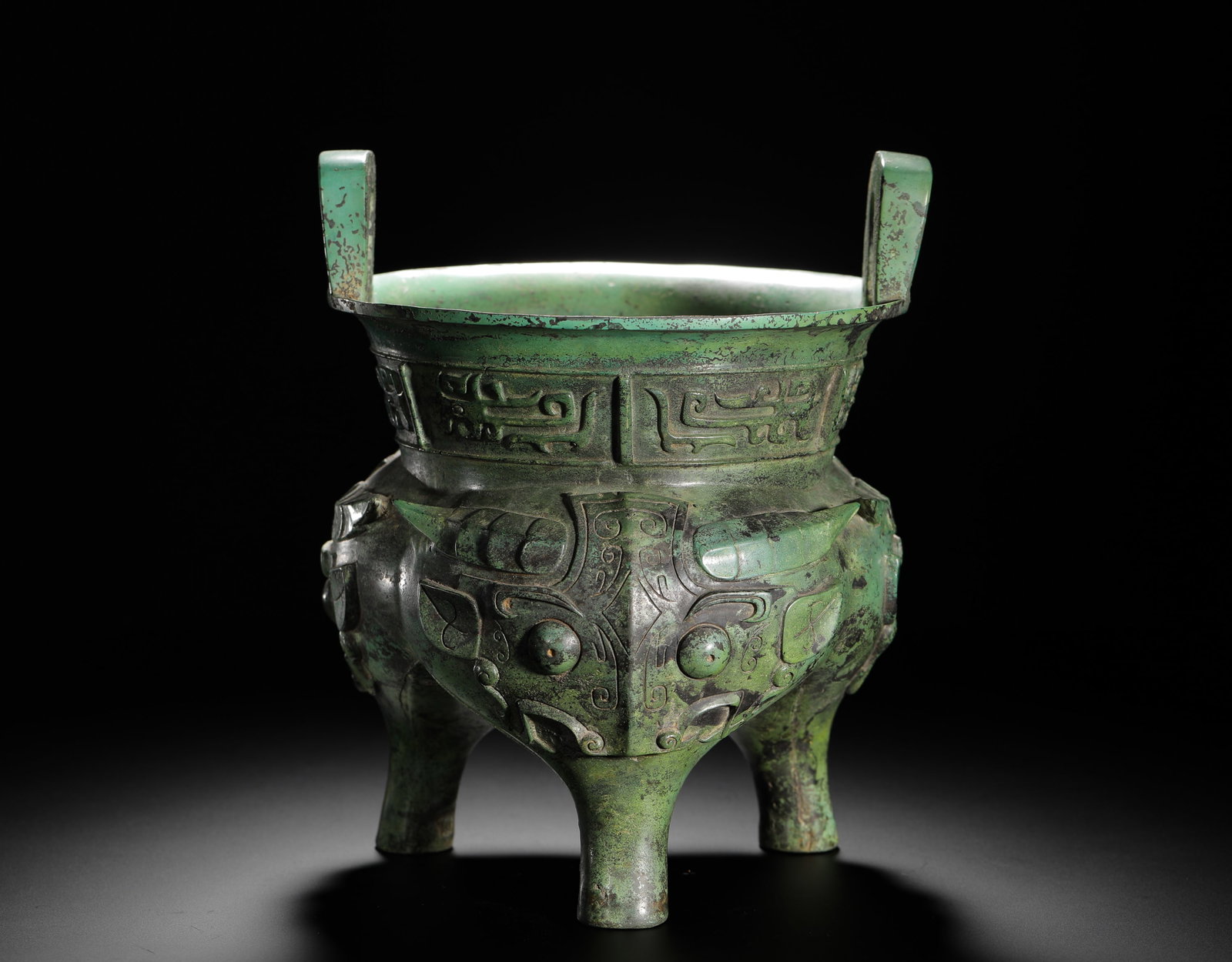 SHANG DYNASTY BRONZE ANIMAL FACE PATTERN ?: H:23cmW:19cmWeight:2440g This is a Shang Dynasty bronze cooking vessel. Decorated with raised animal mask patterns, its solemn design makes it a prime example of Shang ritual culture and bronze castin