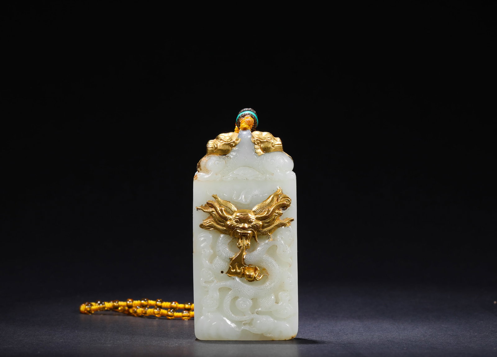 QING DYNASTY HETIAN WHITE JADE INLAID WITH GOLDEN CLOUD AND DRAGON PATTERNS PENDANT: H:8cm(3.15in) W:4cm(1.57in) Weight:110g(0.24lb)This is a Hetian white jade plaque with gold-inlaid cloud and dragon carvings, featuring fine and white jade texture and exquisite craftsmanship, a