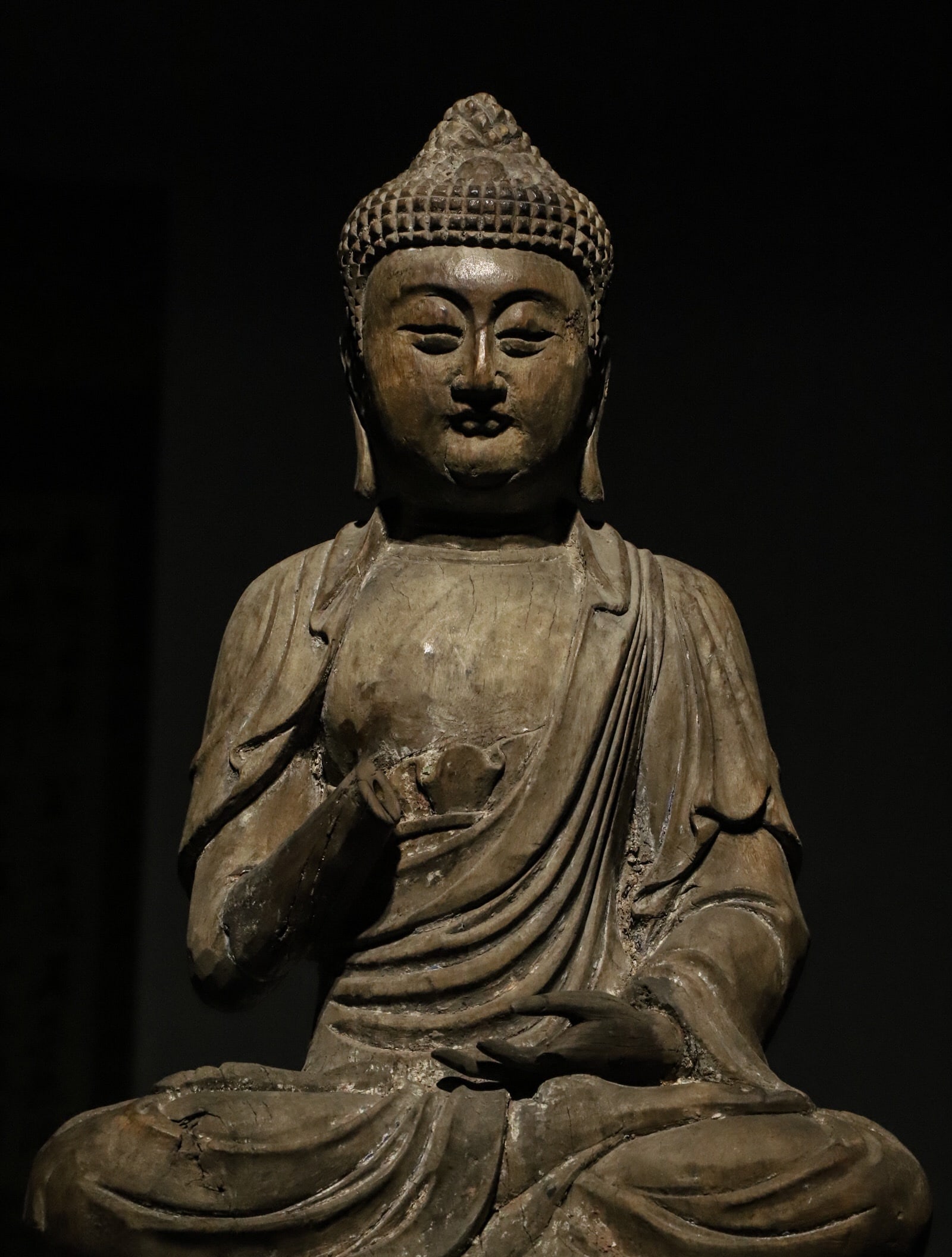 A SEATED STATUE OF SAKYAMUNI MADE OF NANMU WOOD FROM THE MING DYNASTY: H:46cmL:26cmW:20cm The style of this statue combines the solemnity of the Ming Dynasty statues with the secular characteristics of the Qing Dynasty statues. It is a typical representative of the trans