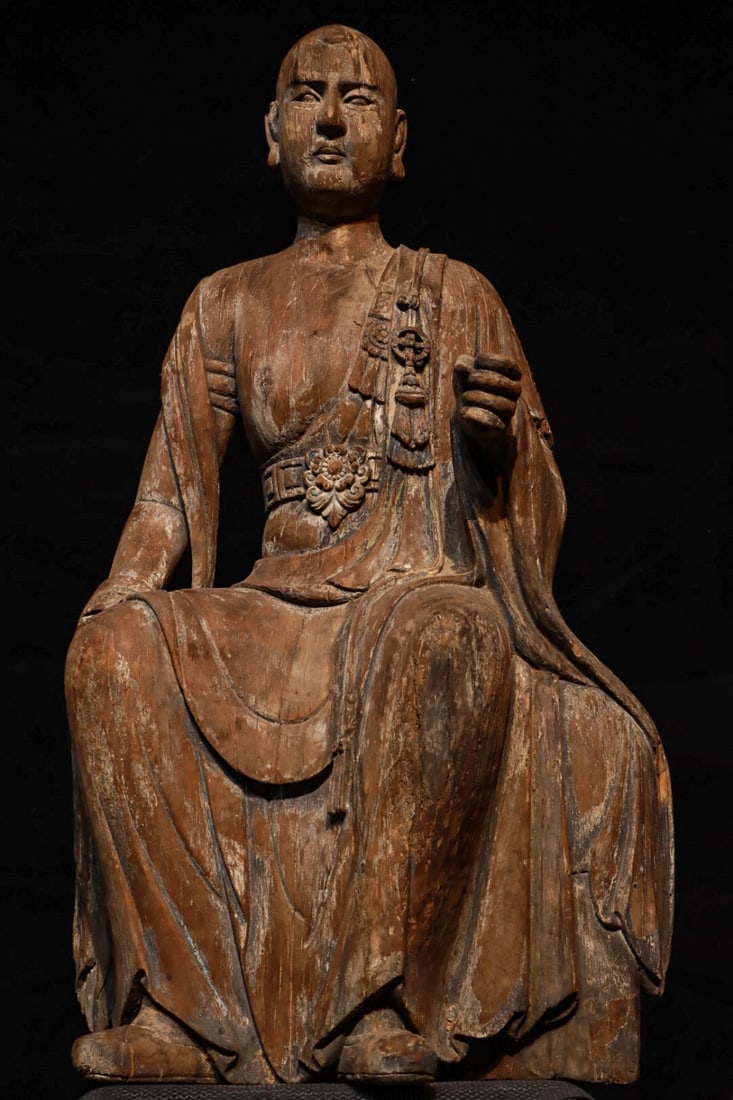 MING DYNASTY NANMU SEATED ARHAT: H:100cmL:60cmW:38cm The style of this statue combines the solemnity of the Ming Dynasty statues with the secular characteristics of the Qing Dynasty statues. It is a typical representative of the tran