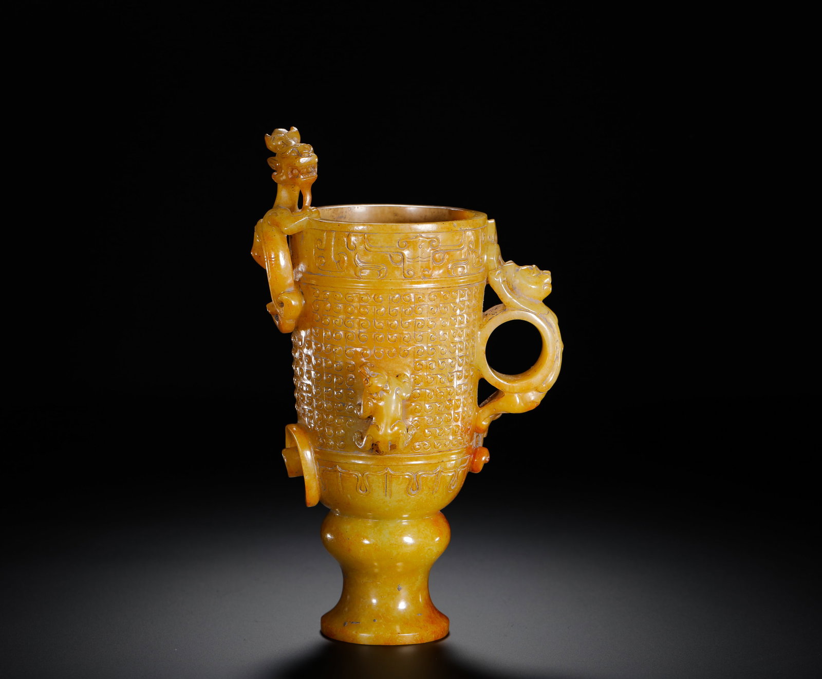 HAN DYNASTY HETIAN YELLOW JADE INTERLOCKING CLOUD PATTERN CHILONG EAR CUP: H:19cm(7.48in)W:10.8cm(4.25in)Weight:50g(0.11lb)Jade cups were often used as drinking vessels by the nobility in the Han dynasty. Yellow jade was highly prized for its noble color. This piece holds im