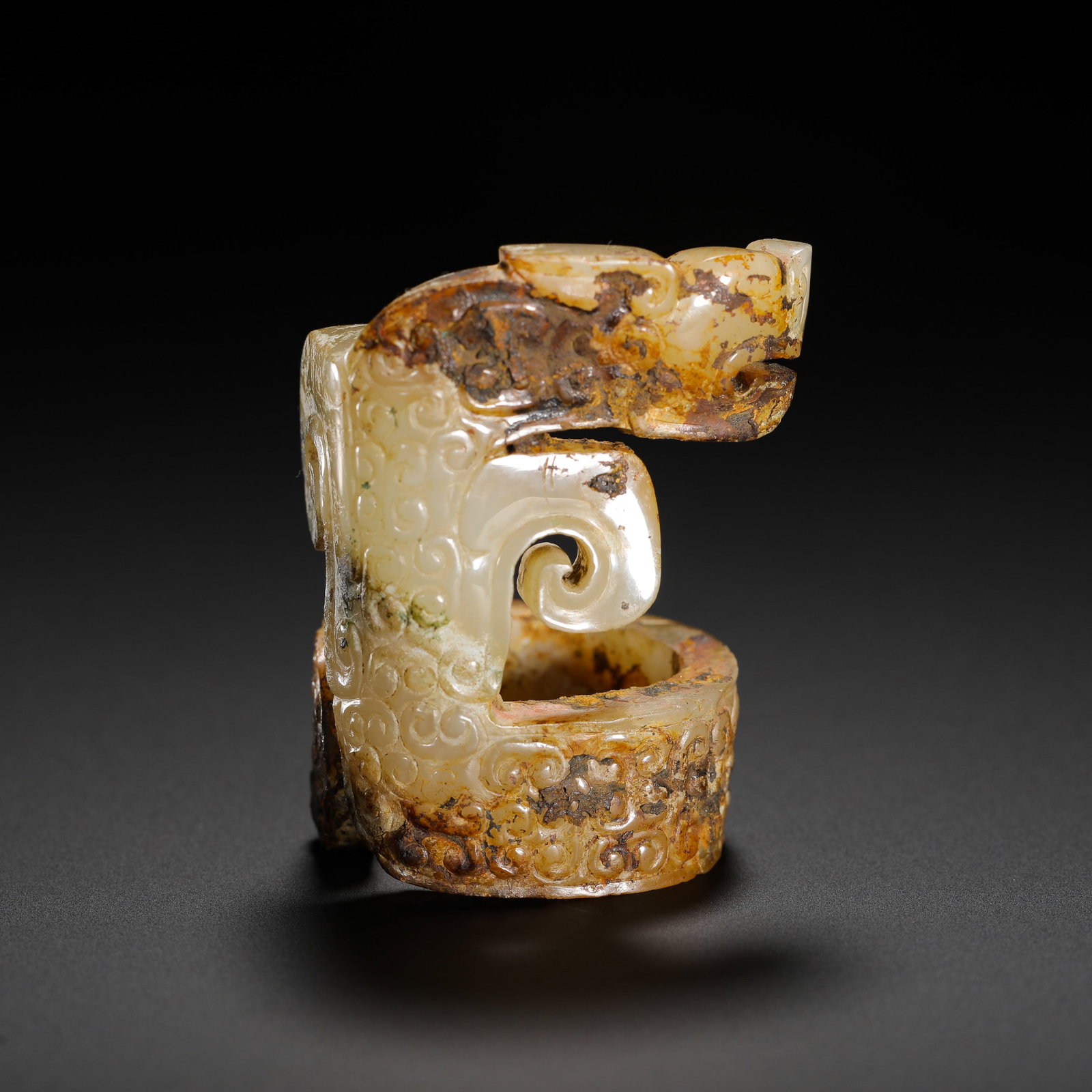 WHITE JADE PENDANT WITH GRAIN PATTERN AND DRAGON HEAD FROM HETIAN IN THE WARRING STATES PERIOD: H:5.2CMW:3.6CMWEIGHT:40GWARRING STATES PERIOD HETIAN WHITE JADE RING-SHAPED DRAGON PENDANT FULLY CARVED WITH GRAIN PATTERNS AND COVERED WITH ANCIENT MINERAL PATINA.