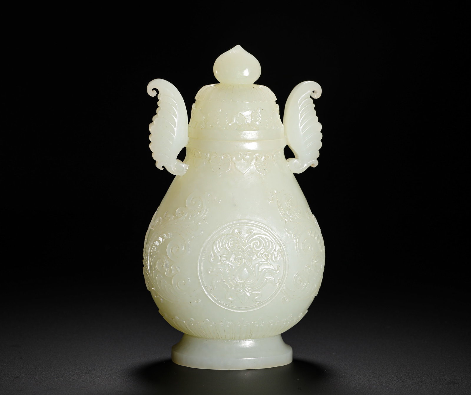 QING DYNASTY HETIAN WHITE JADE DOUBLE BAT EARS AND TWIN-BRANCH GEM-LIKE PATTERN CAP BOTTLE: H:16CMW:9CMWEIGHT:440GQING DYNASTY HETIAN WHITE JADE COVERED VASE WITH TWIN BAT-SHAPED EARS AND CARVED SCROLLING LOTUS PATTERNS, PEACH FINIAL, BULBOUS BELLY AND RING FOOT.