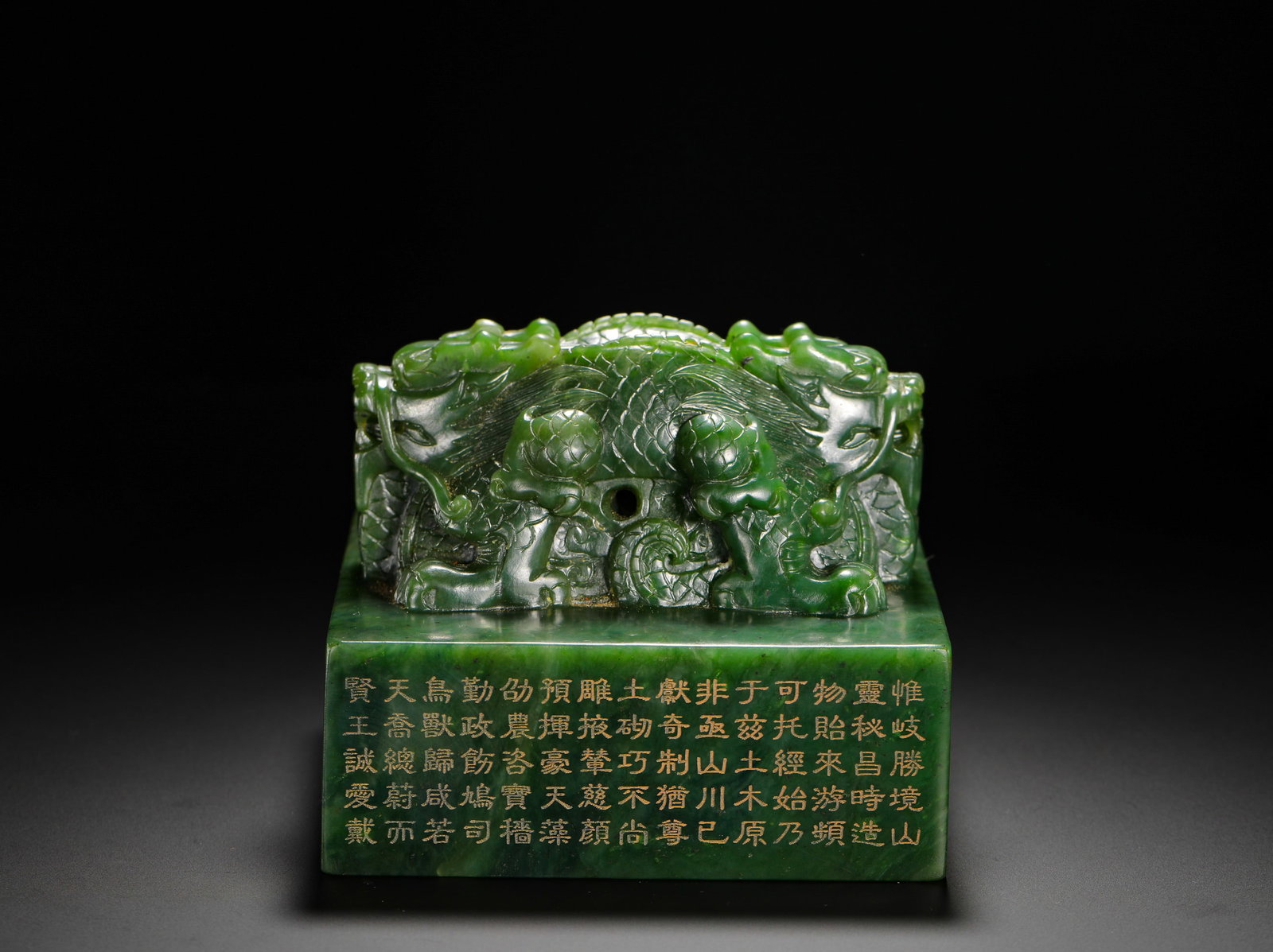 QING DYNASTY HETIAN JADE WITH A DRAGON-KNOB IMPERIAL SEAL OF POETRY AND PROSE: H:10CMW:12.5CMWEIGHT:2980GQING DYNASTY HETIAN SPINACH JADE IMPERIAL SEAL WITH INTERTWINED DOUBLE-DRAGON KNOB, THE SQUARE BASE INSCRIBED WITH LONG GILDED IMPERIAL POEMS ON FOUR SIDES, TOPPED WITH INTER