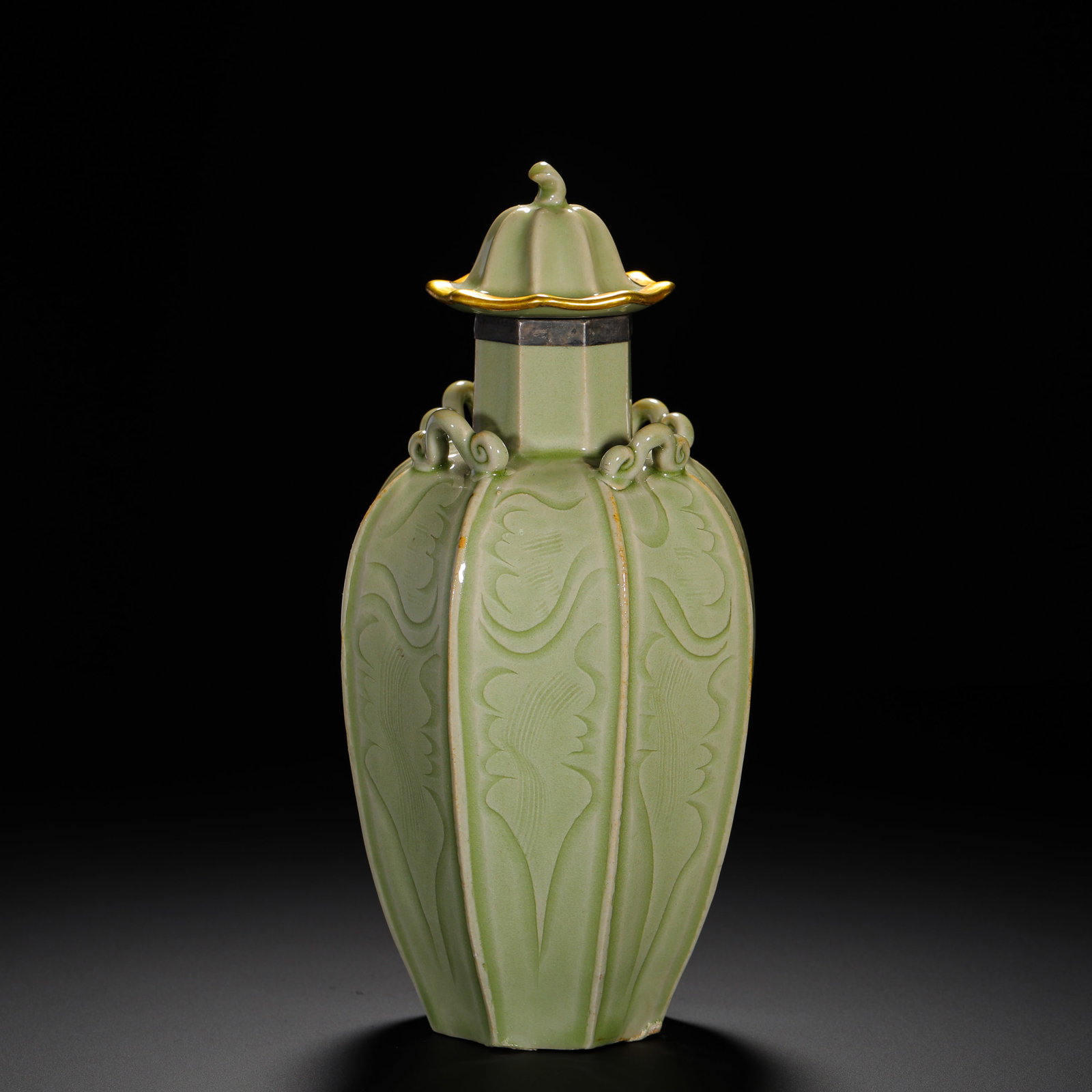 YUAN LONGQUAN KILN MELON RIDGE CAP BOTTLE: HEIGHT:21CM (8.27IN) WIDTH:10CM (3.94IN) WEIGHT:480G (1.06LB) LONGQUAN CELADON COVERED VASE WITH CARVED FLORAL PATTERN AND FOUR LUGS, YUAN DYNASTY. COVERED IN SOFT PINKISH GREEN GLAZE, IT TAKES AN EIG