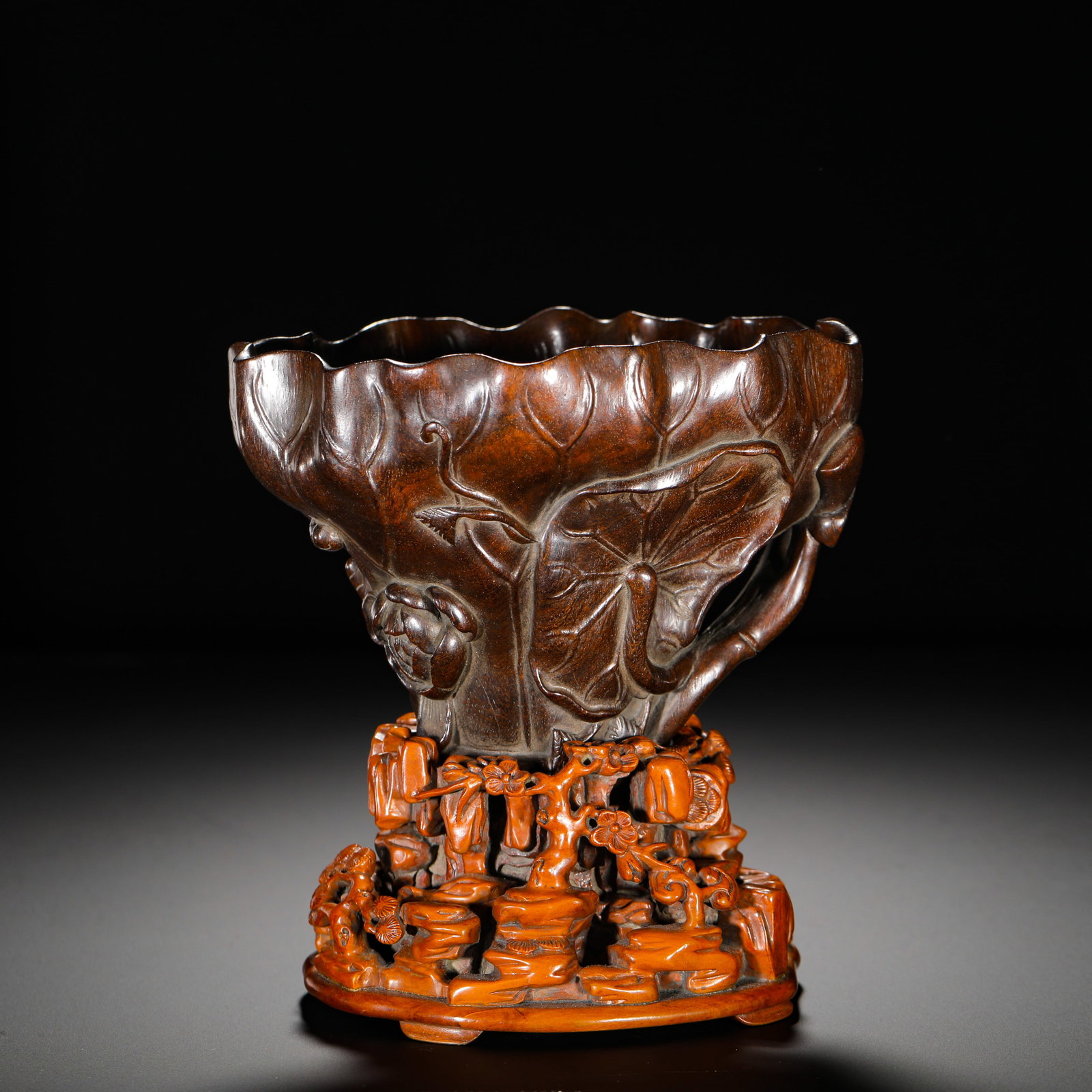 QING DYNASTY PURPLE SANDALWOOD LOTUS LEAF-SHAPED CUP: HEIGHT:16CM (6.30IN) WIDTH:13CM (5.12IN) WEIGHT:690G (1.52LB) QING DYNASTY CARVED WOOD SCHOLAR??S ??ORNAMENT, LOTUS-LEAF CUP MADE OF SOLID RED SANDALWOOD. WAVY RIM, EXTERIOR RELIEF CARVED LOTUS BRANCH