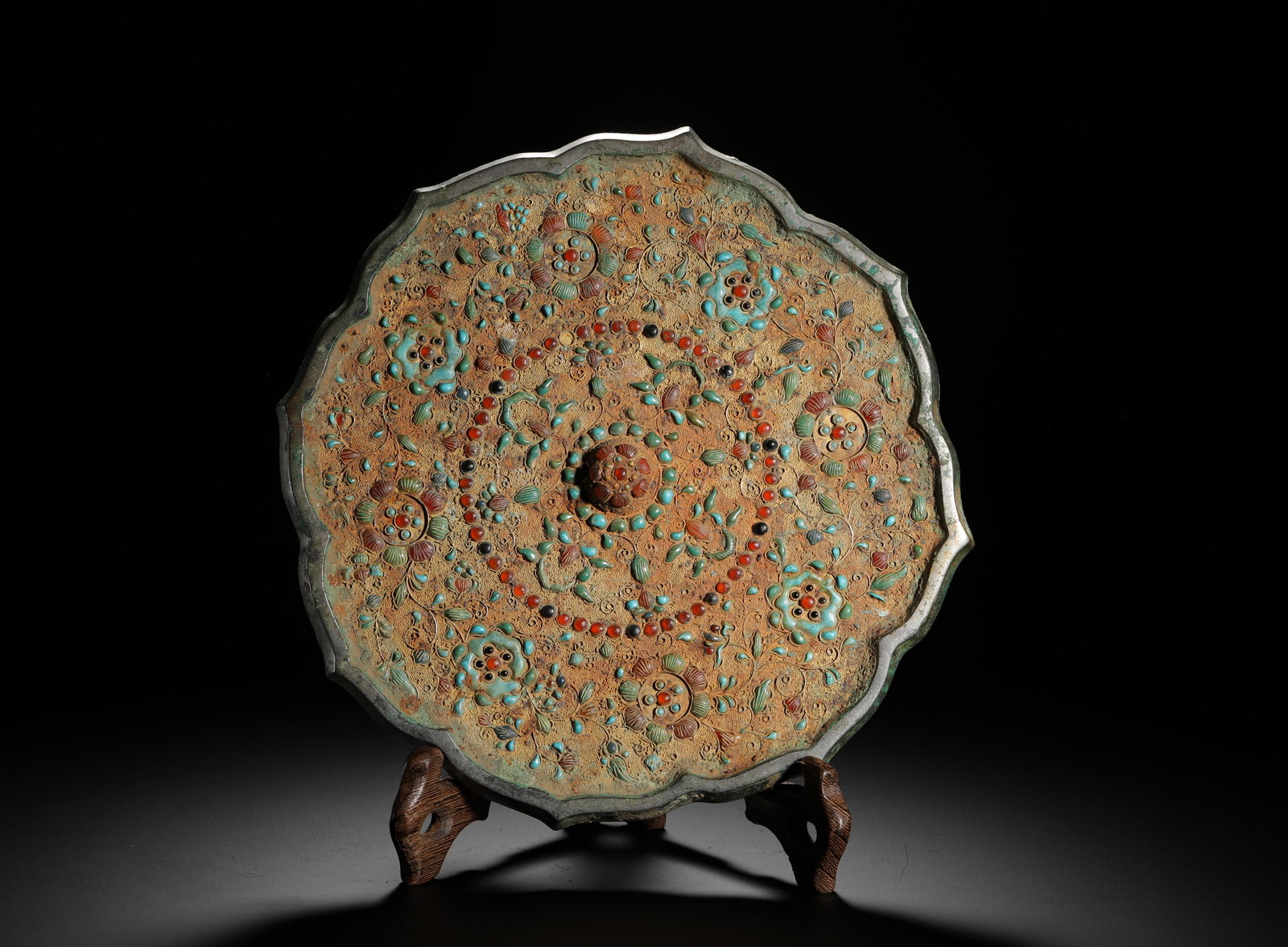 TANG DYNASTY DIAMOND-SHAPED BRONZE MIRROR WITH INLAID GEMSTONES AND ENTANGLED BRANCHES: D:20CM (7.87IN) WEIGHT:1140G (2.51LB) A TANG DYNASTY OCTAGONAL RHOMBUS BRONZE MIRROR INLAID WITH GEMSTONES AND INTERLOCKING LOTUS PATTERNS. THE RIM IS SHAPED AS EIGHT LOBED PETALS. THE REVERSE IS FULL