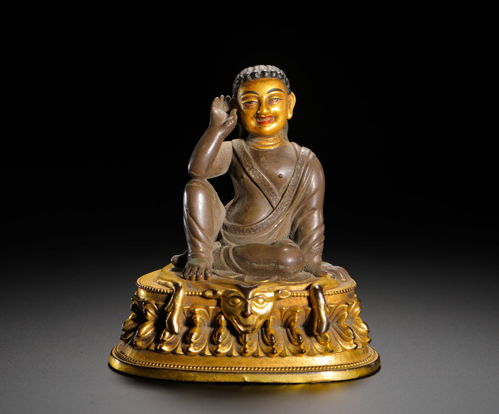 A GILDED BRONZE STATUE OF MILAREPA FROM THE QING DYNASTY: HEIGHT:11CM (4.33IN) WIDTH:9CM (3.54IN) WEIGHT:360G (0.79LB) COPPER STATUE OF MILAREPA, QING DYNASTY TIBETAN BUDDHISM. THE LOTUS PEDESTAL IS FULLY GILDED WHILE THE MAIN FIGURE RETAINS NATURAL PURPLE C