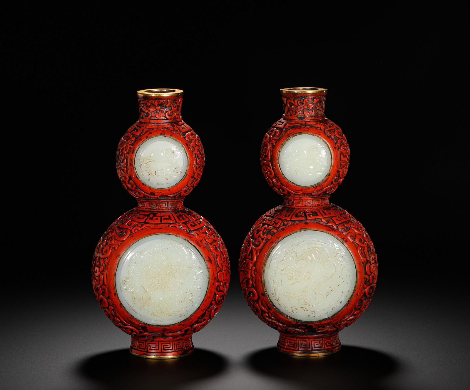 A PAIR OF RED AND WHITE JADE GOURD-SHAPED ORNAMENTAL VASES FROM THE QING DYNASTY: H:20CMPAIR OF QING DYNASTY CARVED RED LACQUER DOUBLE-GOURD DISPLAY VASES WITH FLOWER SCROLLS AND INSET HETIAN WHITE JADE DRAGON-PHOENIX PANELS, FULLY COVERED IN CARVED SCROLL AND GEOMETRIC PATTERNS, F