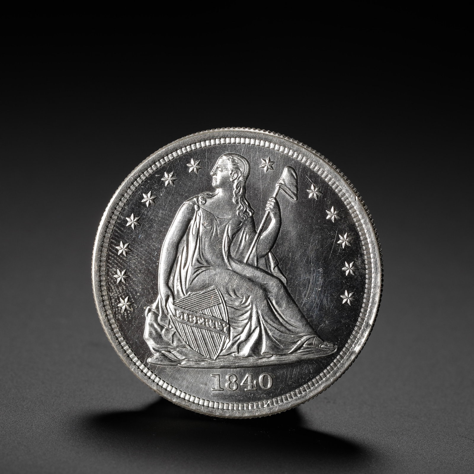 AMERICAN SILVER COIN: D:3.9CM (1.54IN) WEIGHT:27G (0.06LB) A MID-PERIOD REPRESENTATIVE ISSUE OF THE SEATED LIBERTY SILVER DOLLAR SERIES, CONTINUING THE CLASSIC GOBRECHT DESIGN AND SERVING AS AN IMPORTANT CIRCULATING SILVER