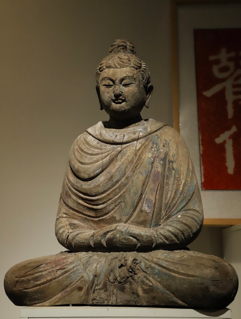 A WOODEN STATUE OF SAKYAMUNI BUDDHA FROM THE TANG DYNASTY: H:60CML:48CMW:28CM SAKYAMUNI BUDDHA IS THE FOUNDER OF BUDDHISM. THIS STATUE IS NOT ONLY A CARRIER OF RELIGIOUS BELIEFS, BUT ALSO A TANGIBLE WITNESS OF THE DEEP INTEGRATION OF ANCIENT CHINESE WOODCARVI